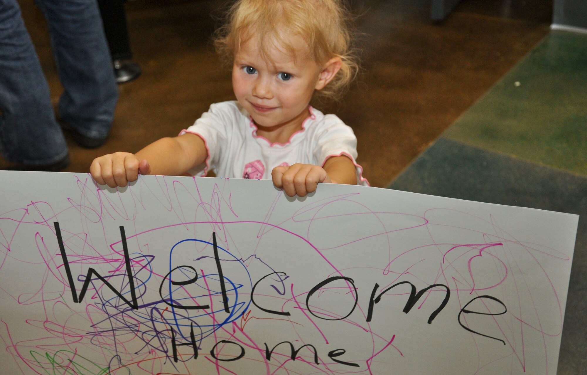 BUCKLEY AIR FORCE BASE, Colo. -- A little girl holds up her handmade sign to welcome home her big sister at the end of Operation Future Forces Aug. 4, 2012.  The children who participated, completed a shortened Basic Military Training and a simulated deployment by the time they returned home.  (U.S. Air Force photo by Staff Sgt. Nicholas Rau)