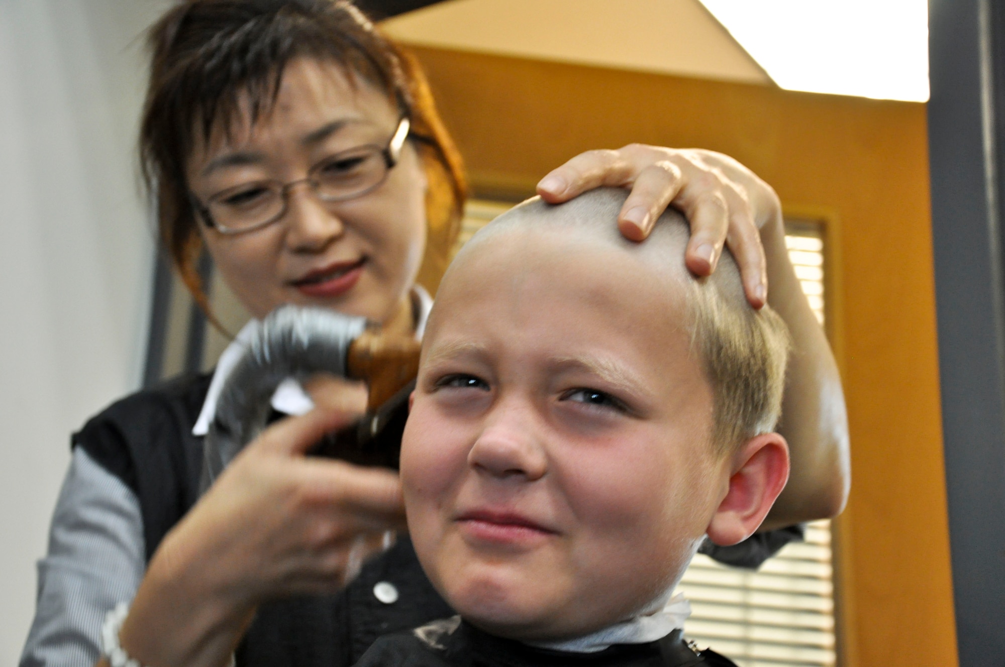 BUCKLEY AIR FORCE BASE, Colo. -- A child gets his haircut at the beginning of Operation Future Forces Aug. 4, 2012.  This event ran the children through a shortened Basic Military Training and a simulated deployment.  (U.S. Air Force photo by Staff Sgt. Nicholas Rau)