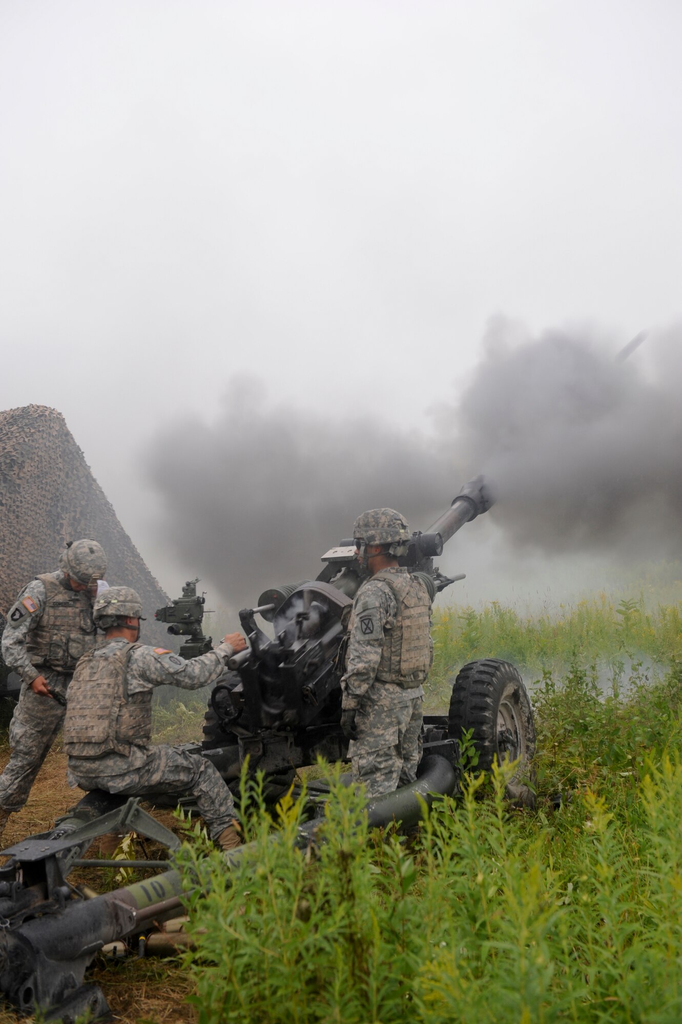 U.S. Army soldiers from the 10th Mountain Division, 3rd Battalion, 6th Field Artillery, Alpha Battery Company, 2nd Platoon, fires an M119 Howitzer at Fort Drum, N.Y., July 26, 2012.The M119 can be moved quickly and employed to provide maximum fire power without requiring a recoil pit. (U.S. Air Force photo by Airman 1st Class Douglas Ellis/Released)
