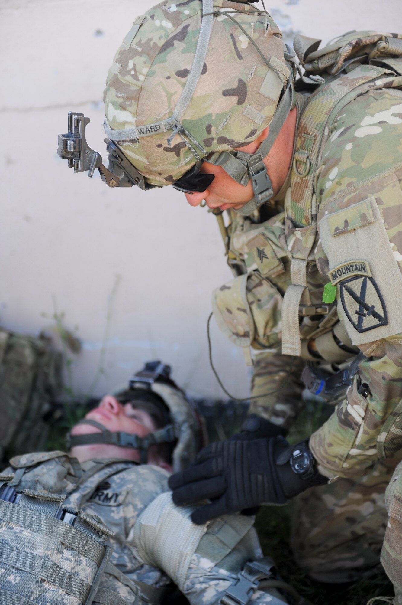 A U.S. Army soldier from the 10th Mountain Division, 4-31 Infantry Battalion, Bravo Company, 2nd Platoon, performs self-aid and buddy care on a soldier from his platoon during a training scenario at Fort Drum, N.Y., July 25, 2012. The scenario gave soldiers an opportunity to gain experience in a realistic environment before being deployed. (U.S. Air Force photo by Airman 1st Class Douglas Ellis/Released)

