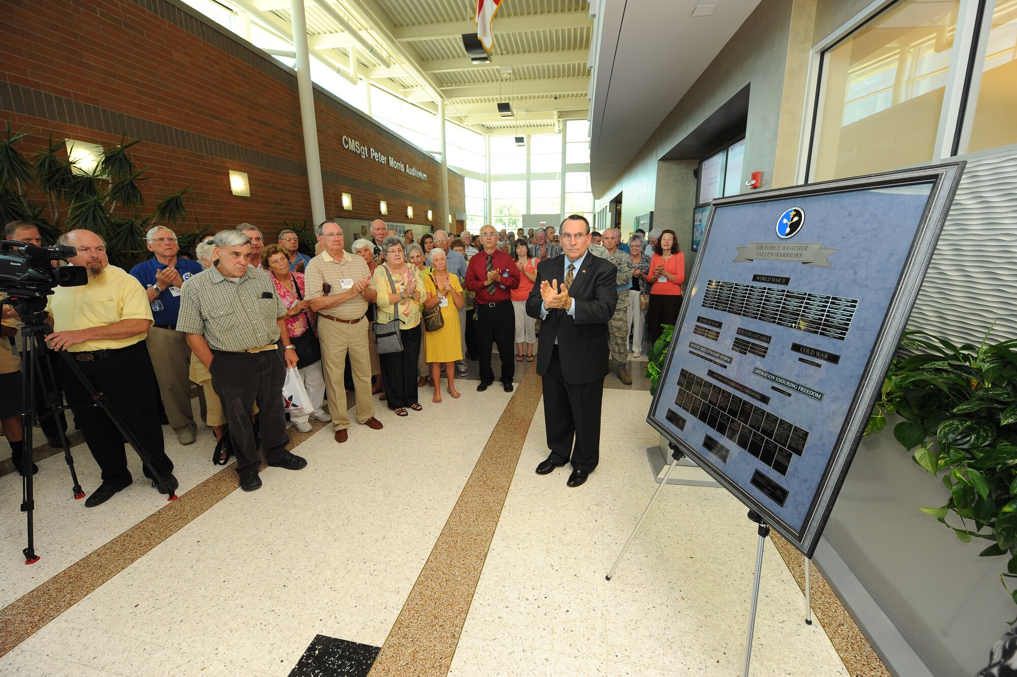 Dr. Fred Lewis, director of Air Force Weather, unveils a Fallen Warrior plaque, in the AFWA auditorium, to commemorate those who gave all during each of military campaigns since weathers inception, Offutt Air Force Base, Neb. Aug. 2.  (U.S. Air Force Photo by Josh Plueger/Released)