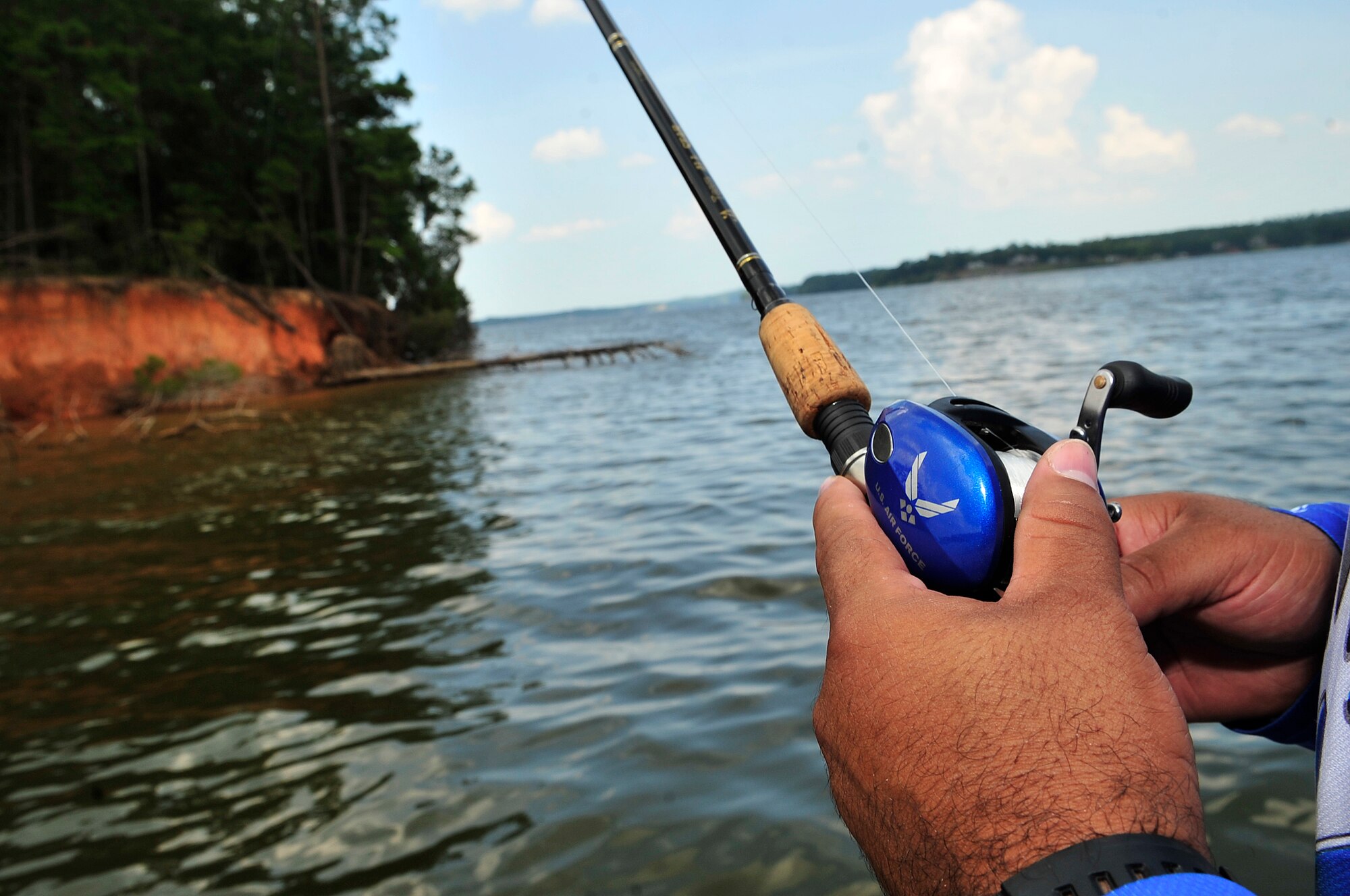 Ray Heredia, U.S. Air Forces Central and 9th Air Force video teleconference engineer, casts a lure as he fishes from his Legend Air Force speed boat, Wateree Lake, S.C., Aug. 3, 2012.  Heredia has been competing in bass fishing tournaments since 1994.  He uses the boat for bass fishing tournaments, guided fishing tours and Air Force recruiting.(U.S. Air Force photo by Airman Nicole Sikorski/Released) 