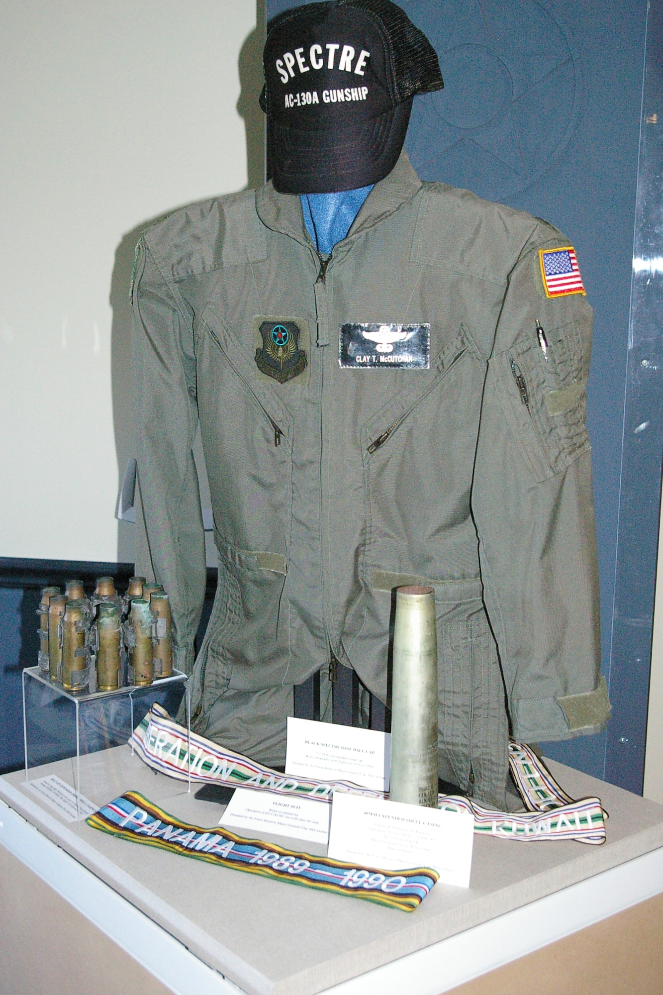 This display case of items from Operations Just Cause, Desert Shield and Desert Storm includes a flight suit, cap and spent Bofors 40mm gun shell casing donated by retired Maj. Gen. Clay McCutchan. (U.S. Air Force photo/Keith Barr)