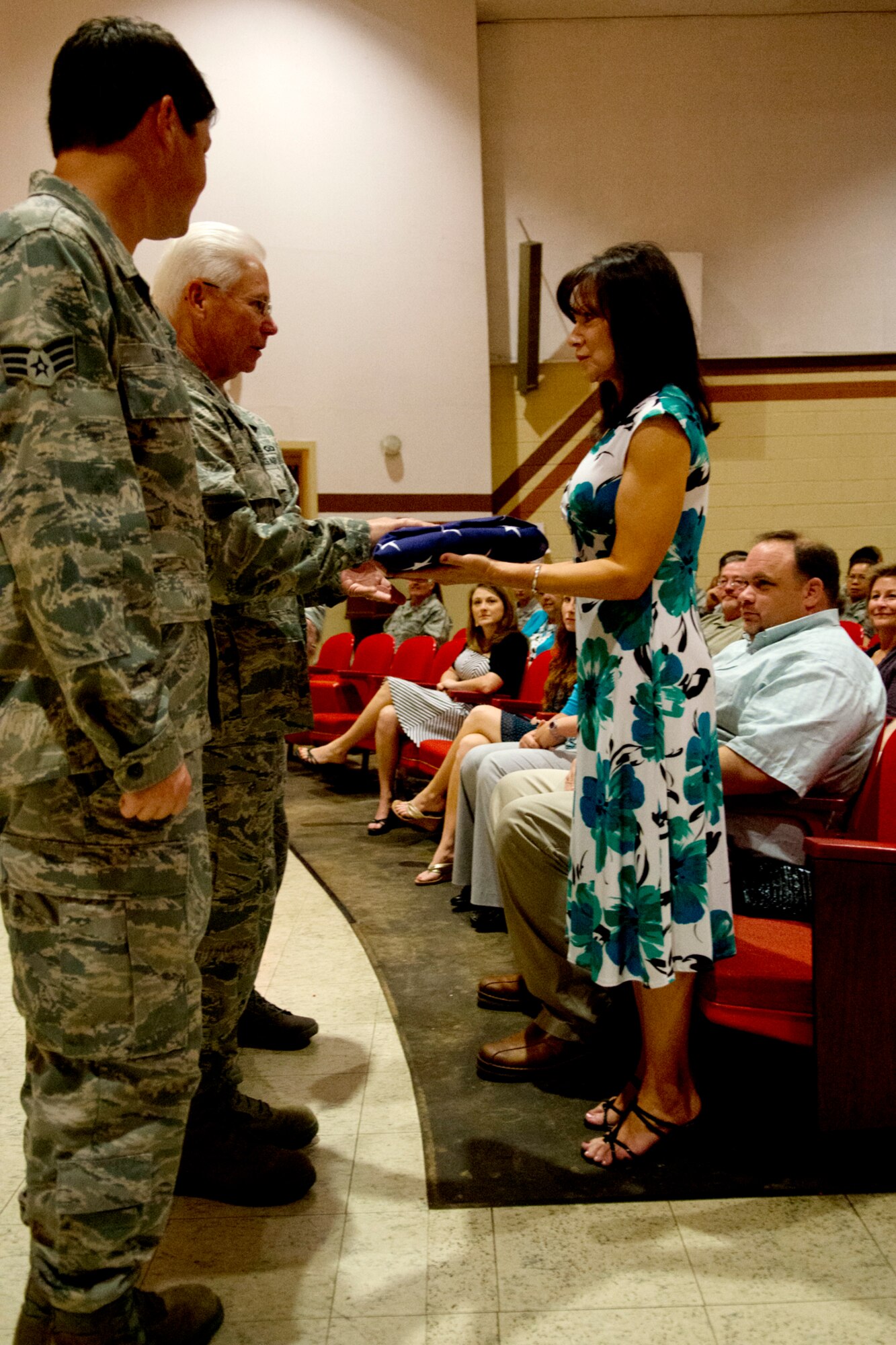 Family and friends watch as U.S. Air Force Lt. Col. Allen Smith presents his retirement flag to his wife Loretta during his retirement ceremony on Barksdale Air Force Base, La., Aug. 5, 2012. Smith, assigned to the 307th Medical Squadron, retired after serving 35 years in the military. (U.S. Air Force photo by Master Sgt. Greg Steele/Released)