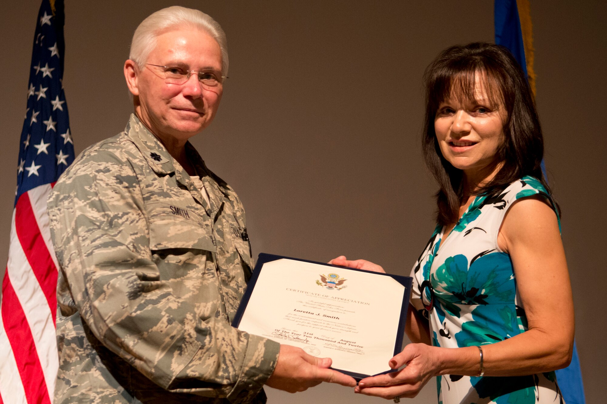 Loretta Smith is presented the spouse Certificate of Appreciation by her husband, Lt. Col. Allen Smith, during his retirement ceremony on Aug. 5, 2012, Barksdale Air Force Base, La. Smith is assigned to the 307th Medical Squadron and is retiring after serving 35 years in the military. (U.S. Air Force photo by Master Sgt. Greg Steele/Released)