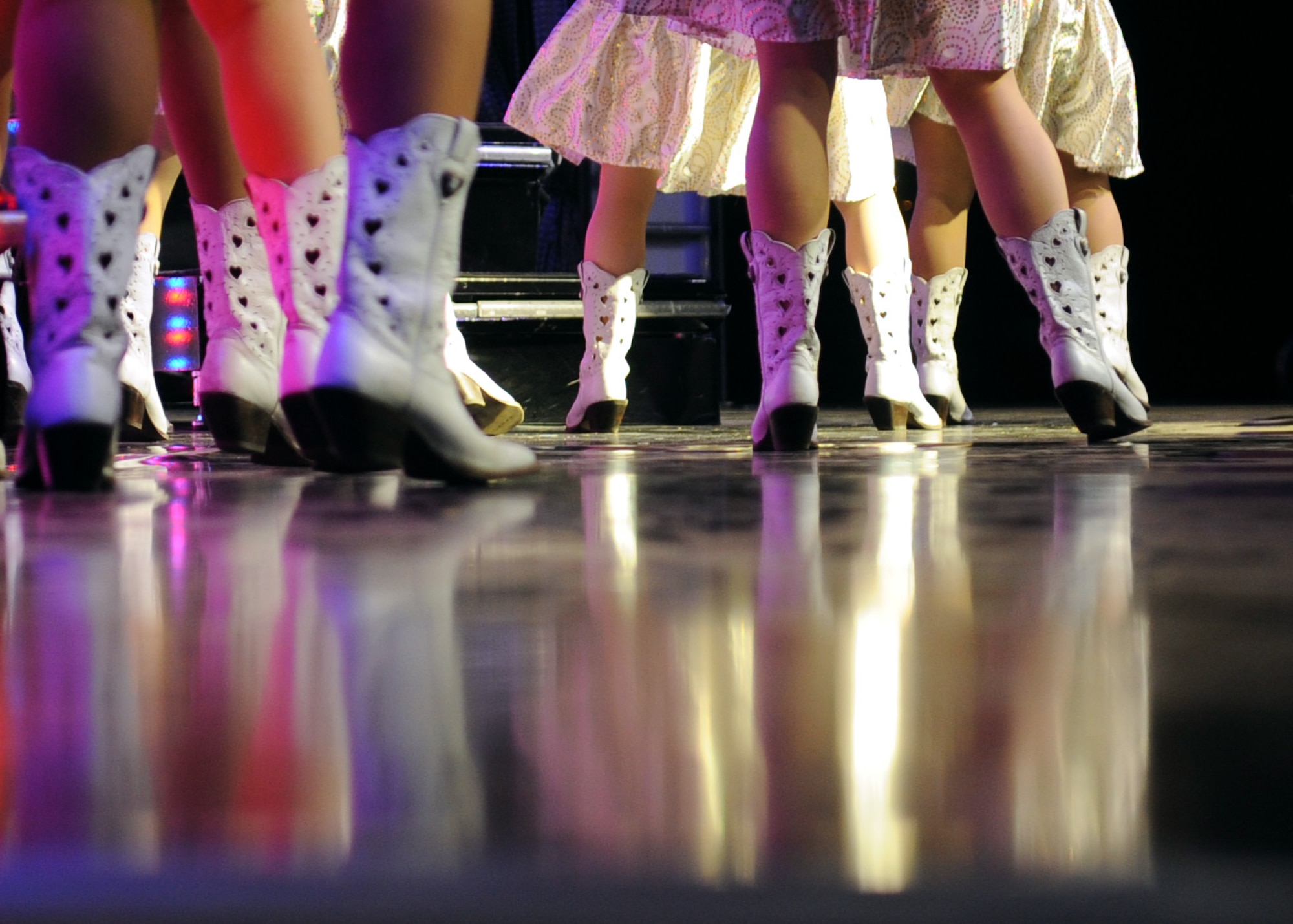 ALTUS AIR FORCE BASE, Okla. – Tops in Blue vocalists sing and dance in their cowboy boots during the Tops in Blue concert held at Wings of Freedom Park, Aug. 4, 2012. Tops in Blue members serve as ambassadors for the U.S. and the U.S. Air Force while providing quality entertainment for  Air Force members, families, and local communities. (U.S. Air Force photo by Airman 1st Class Klynne Pearl Serrano / 97th Air Mobility Wing / Released)