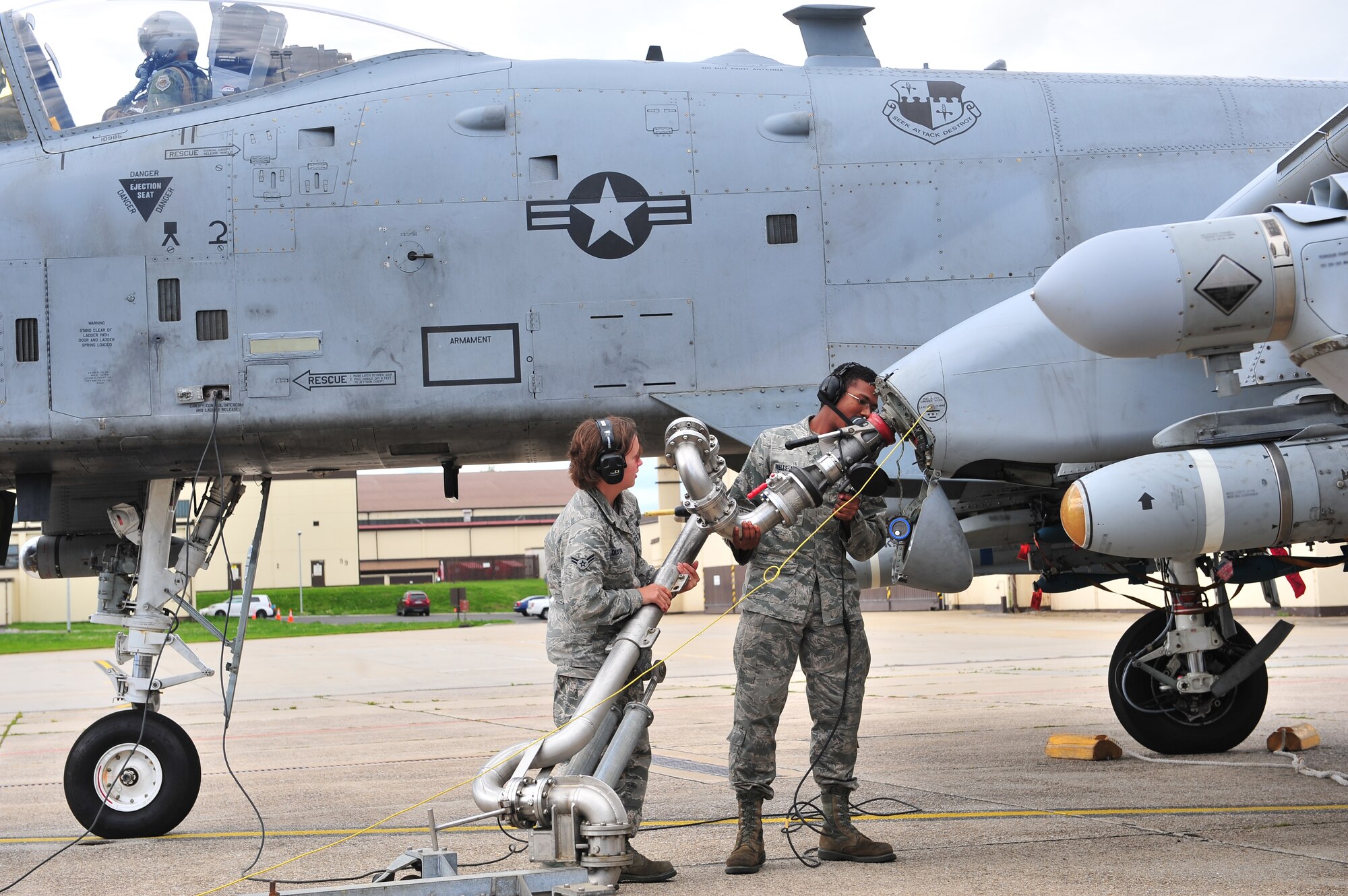 SPANGDAHLEM AIR BASE, Germany – Airman 1st Class Heather Dixon, left, 52nd Logistics Readiness Squadron fuels distribution operator, and Airman 1st Class Anthony Wells-Johnson, 52nd Aircraft Maintenance Squadron avionics maintenance technician, remove a jet fuel pump from an A-10 Thunderbolt II during a hot pit refueling on Ramp 3 here Aug. 6. A hot pit is the refueling of a jet while the aircraft is still running so pilots can take off right away. The fuels distribution shop quality tests aircraft fuel, conducts hot pit operations and takes accountability for all aircraft fuel. (U.S. Air Force photo illustration by Airman 1st Class Dillon Davis/Released)