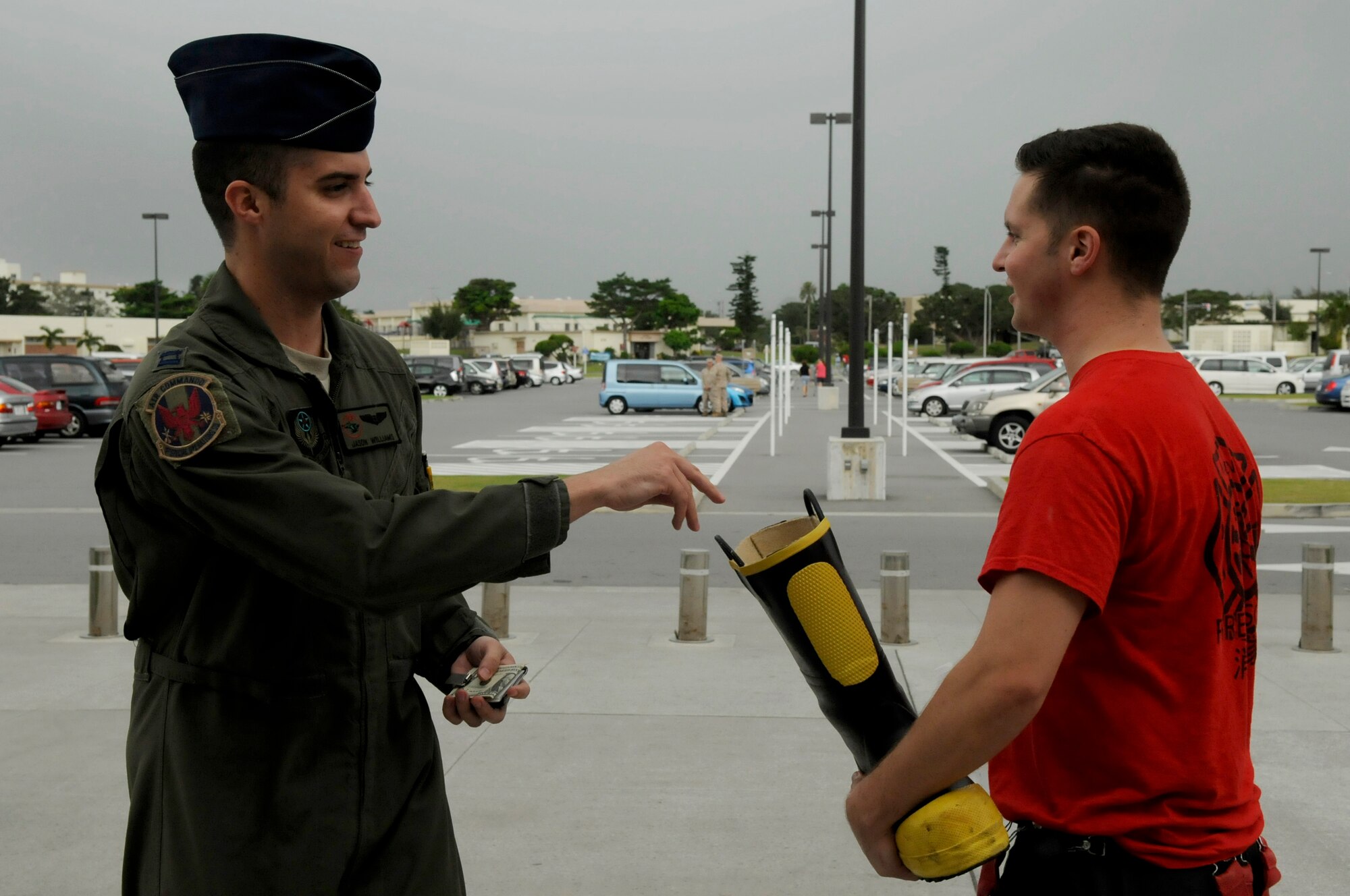 U.S. Air Force Capt. Jason Williams, 1st Special Operations Squadron, gives a donation to Airman 1st Class Robert Castanon, an 18th Civil Engineer Squadron driver/operator, during the Fill-the-Boot campaign to raise money for the Kadena Special Olympics on Kadena Air Base, Japan, Aug. 3, 2012. With the help of Team Kadena, a total of $27,120 was raised throughout the week to help support the 2012 KSO. (U.S. Air Force photo/Airman Tara A. Williamson)