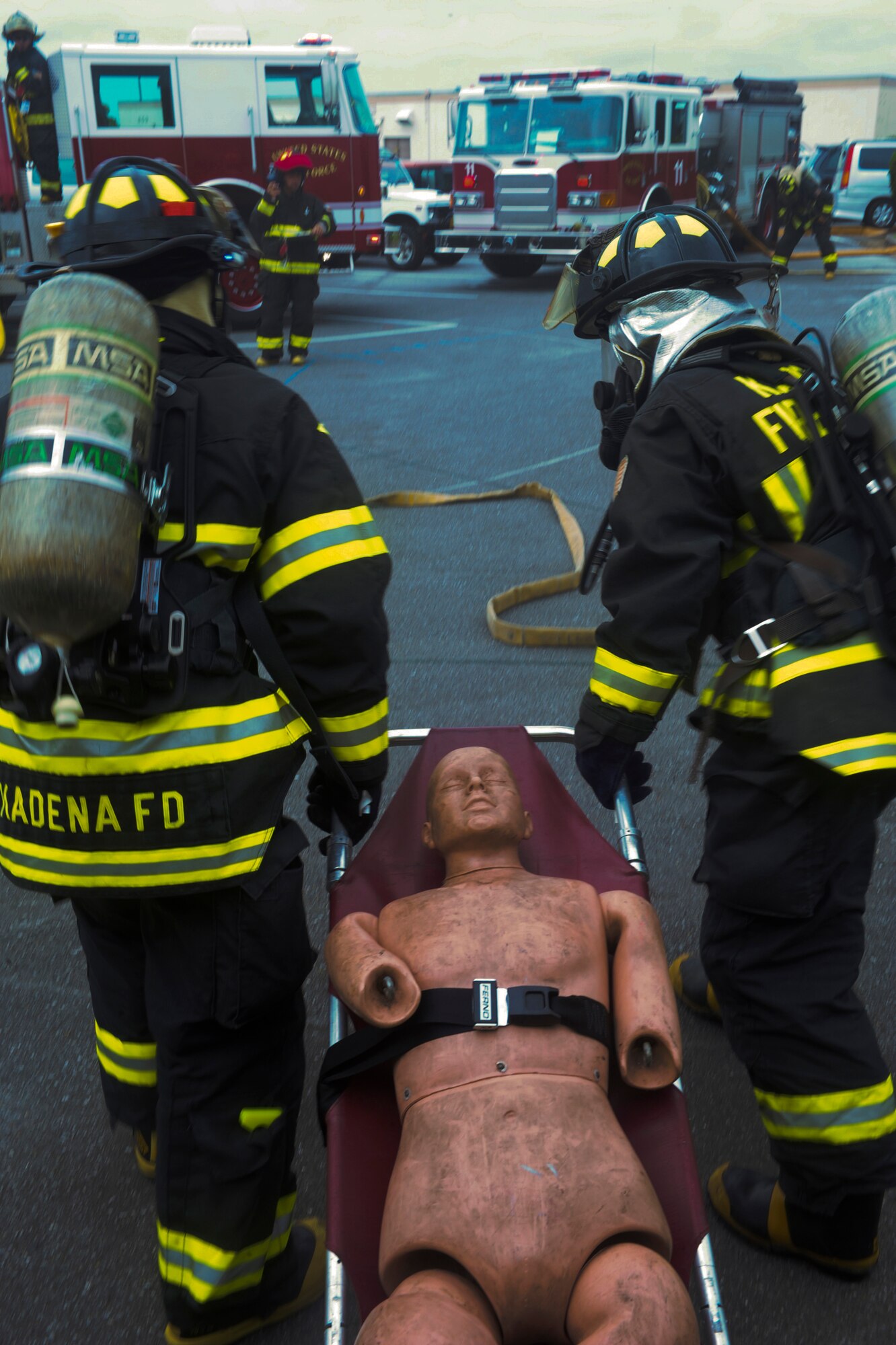 Firefighters from the 18th Civil Engineer Squadron carry a simulated victim out of a burning building during a emergency responder training scenario on Kadena Air Base, Japan, Aug. 2, 2012. Emergency responder scenarios are critical to provide training for firefighters for real world contingencies. (U.S. Air Force photo/Airman 1st Class Justin Veazie)