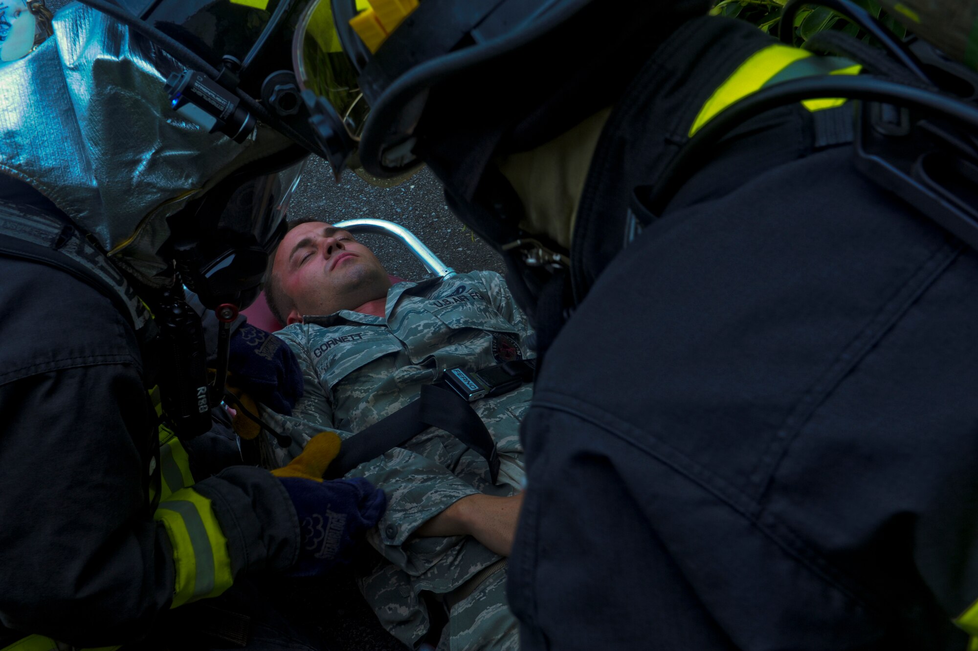 Firefighters from the 18th Civil Engineer Squadron strap U.S. Air Force Staff Sgt. Brennen Cornett, 18th Civil Engineer Squadron firefighter, to a litter during a training scenario on Kadena Air Base, Japan, Aug. 2, 2012. Attention to detail is a crucial step while conducting scenarios to ensure the safety of both victims and responders.  (U.S. Air Force photo/Airman 1st Class Justin Veazie)