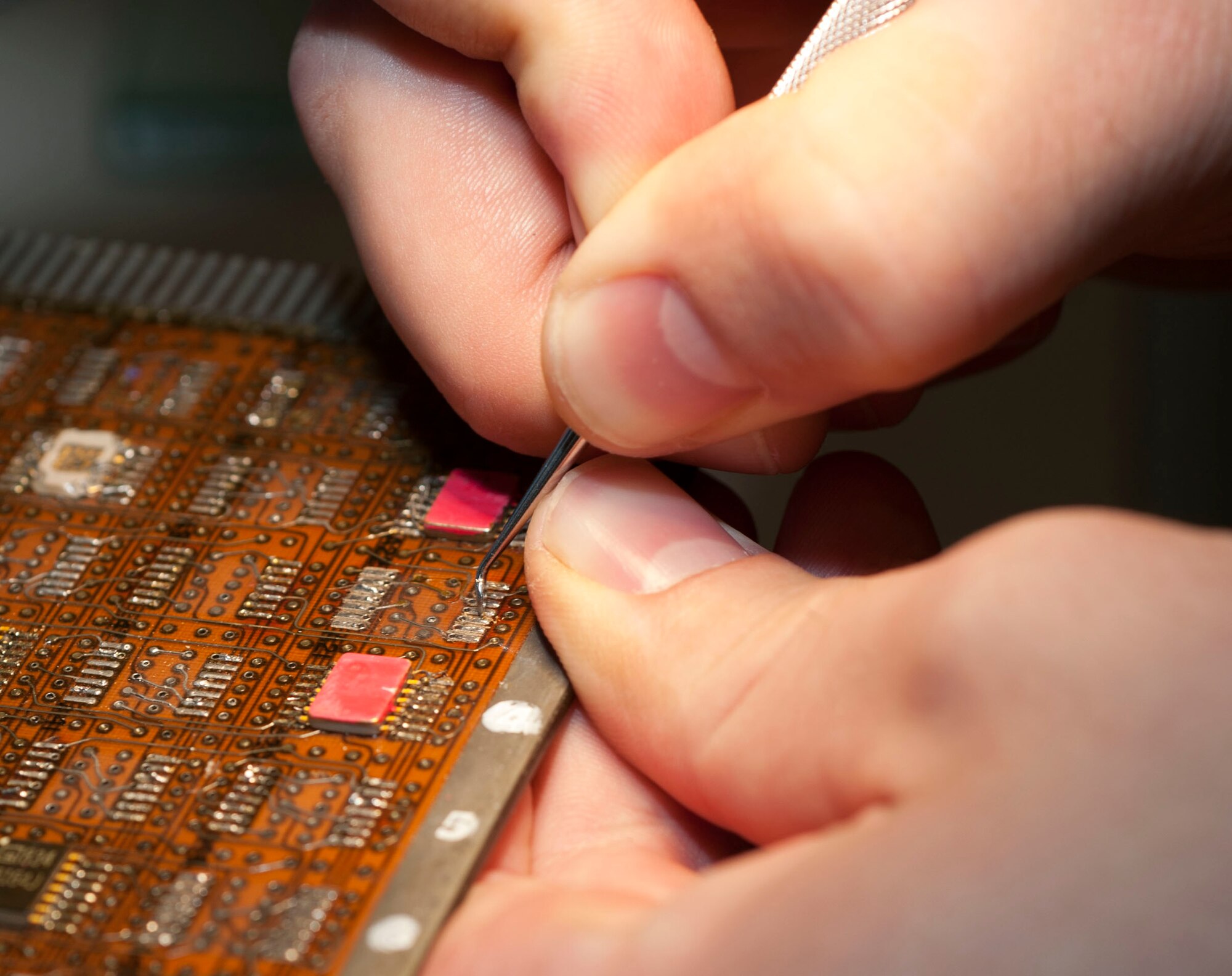 SPANGDAHLEM AIR BASE, Germany – Staff Sgt. Will Robinson, 372nd Training Squadron A-10 Thunderbolt II avionics instructor, removes a dual in-line package from a circuit board as part of a grading step during the Miniature and Micro-miniature Repair Program at the 372nd TRS’ Detachment 17 here. The 2M course is a U.S. Navy certification program, which teaches Airmen how to do in-house repairs on circuit board components that would otherwise be sent back to the manufacturer or to heavy maintenance for repair or thrown away. Last year, the program saved U.S. Air Forces in Europe $4.8 million. (U.S. Air Force photo by Senior Airman Natasha Stannard/Released)
