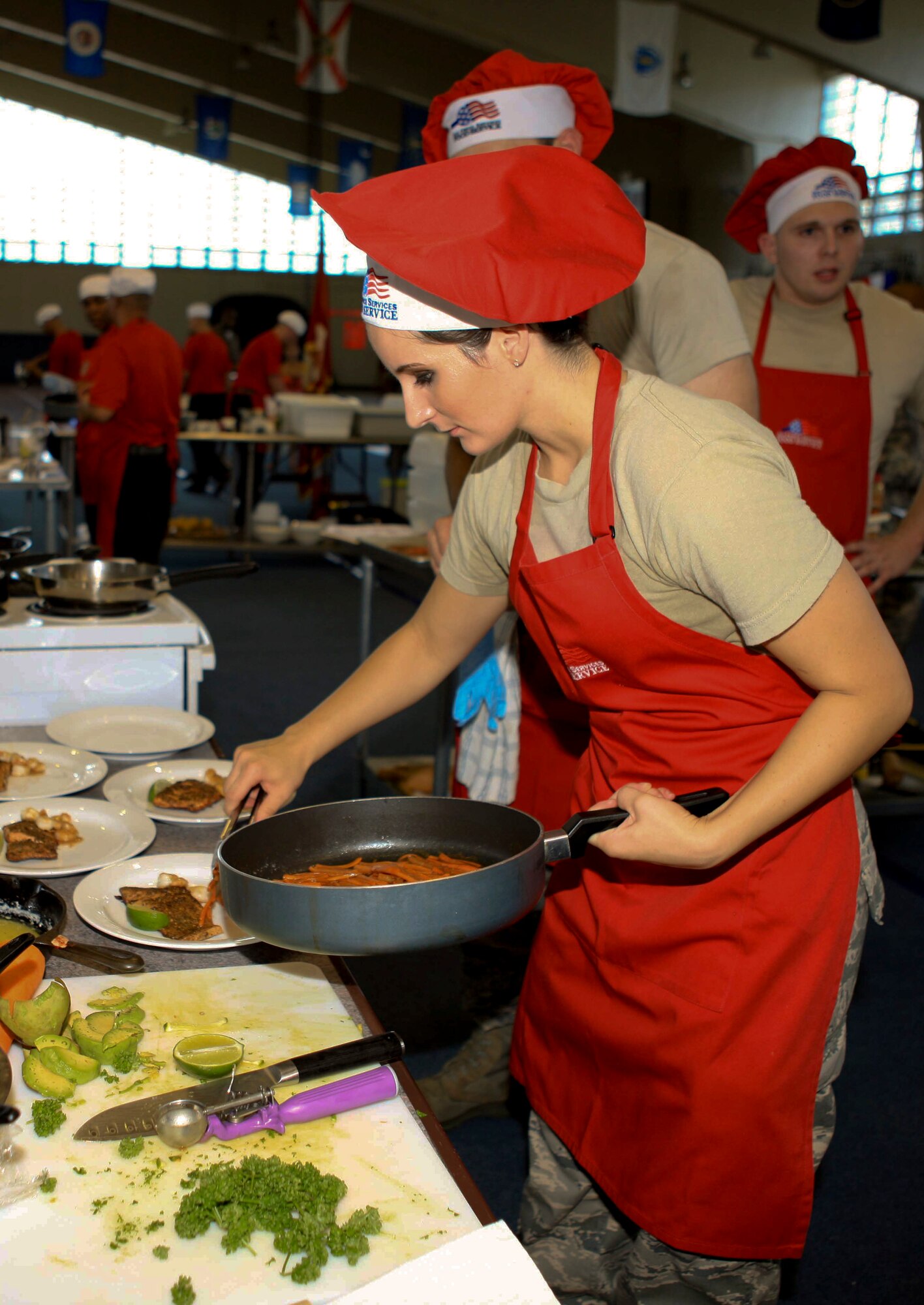 Senior Airman Jessica Ashe, 18th Force Support Squadron fitness specialist, prepares a dish at the Okinawa Inter-Service Cook-Off on Camp Foster, Japan, July 28, 2012. Ashe and members of the 18th FSS competed in the cook-off as part of the Air Force team and took second place. The Army team took first. (U.S. Army photo/Chip Steitz)