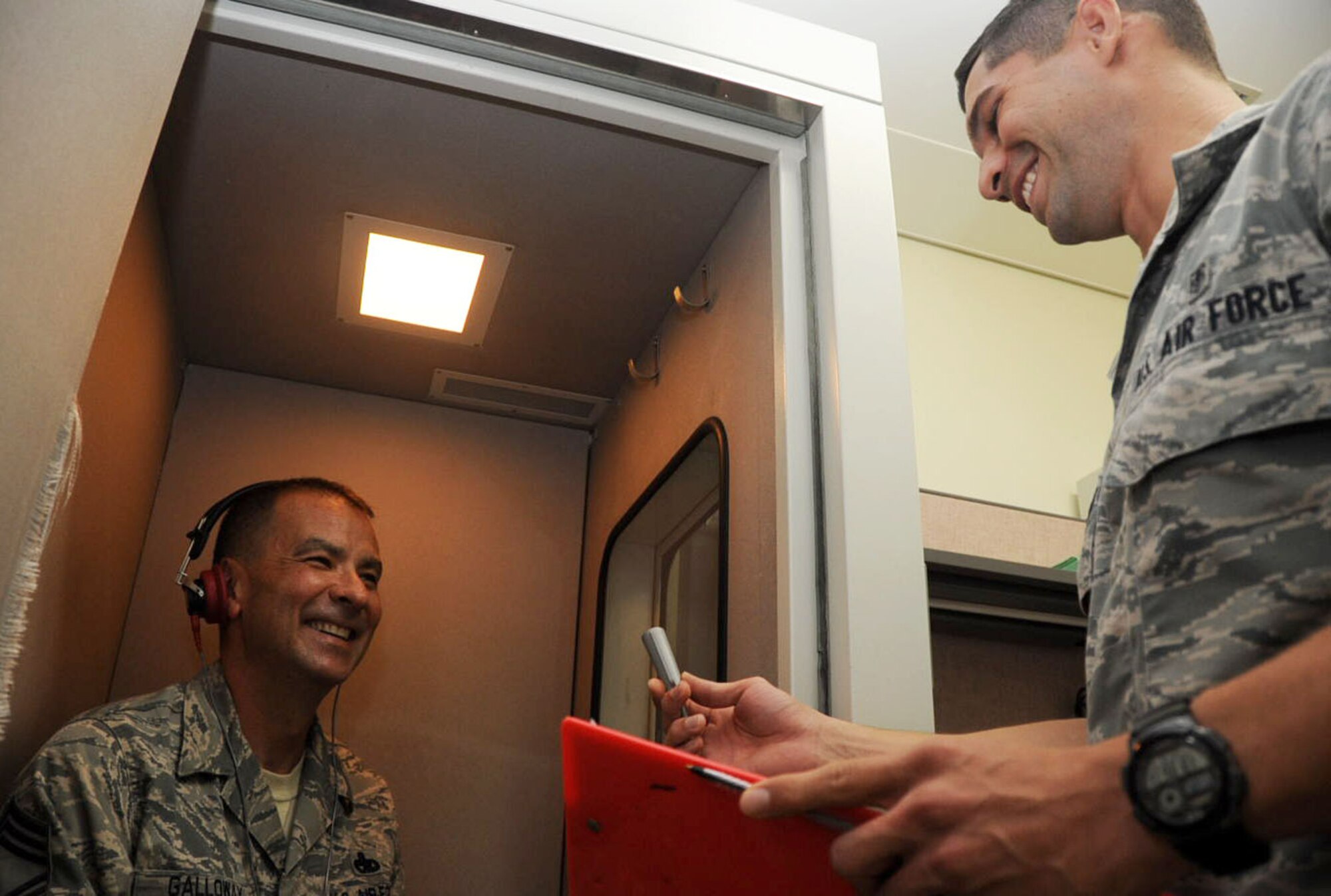 U.S. Air Force Airman 1st Class Miguel Pellot Munoz, right, 35th Aerospace Medical Squadron public health technician, explains how to take the annual audiogram to Chief Master Sgt. Frank Galloway, 35th Maintenance Group wing weapons manager, at Misawa Air Base, Japan, Aug. 7, 2012. Military members belonging to certain careers are required to take an annual audiogram to diagnose if he or she is suffering from hearing loss. (U.S. Air Force Airman 1st. Class Kenna Jackson/Released)