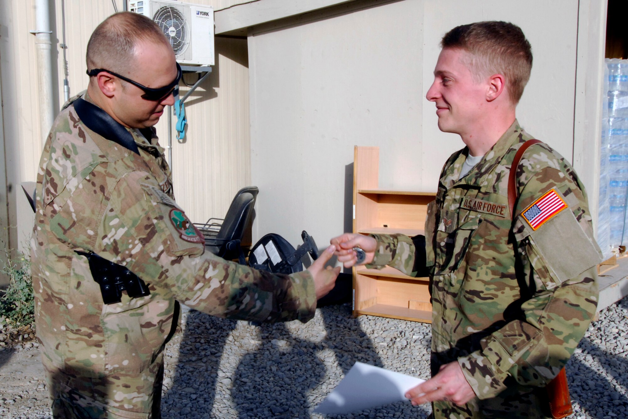 MSgt Scott Czerwinski (left), 774th Expeditionary Airlift Squadron First Sergeant, “coins” Senior Airman Philip Hansen, 774 EAS Joint Airdrop Inspector, after presenting Hansen the “Diamond Sharp” award at Bagram Airfield, Afghanistan, Aug. 7, 2012. The “Diamond Sharp” award is presented by the 1st Sergeants Group to an Airman in a unit who stands out amongst their peers based on professionalism, performance of duty, and wear of uniform. With the Diamond Sharp Award having just been revamped, Hansen was the first Airman to receive the award since it started back up. (U.S. Air Force photo/SSgt Jeff Nevison)