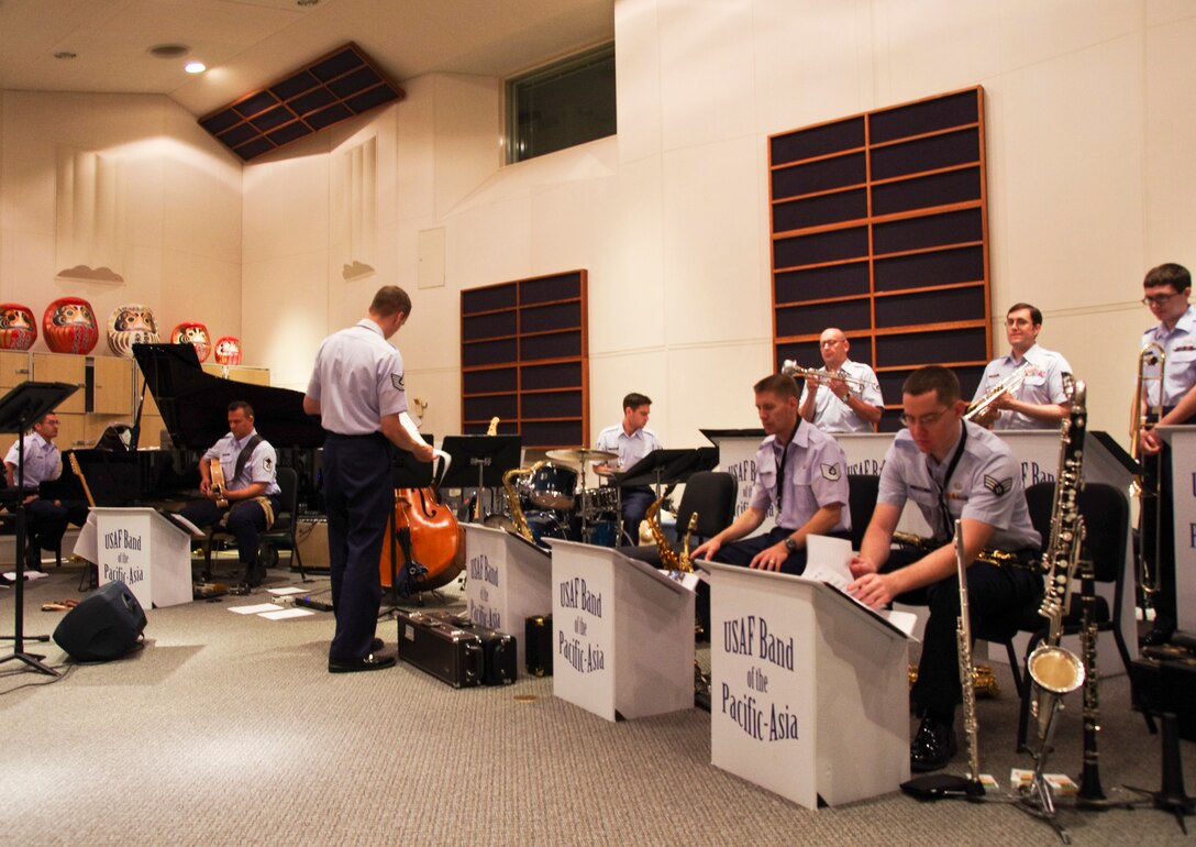 YOKOTA AIR BASE, Japan -- Senior Airman Greg Pflugh, Band of the Pacific-Asia saxophonist, lower right, places music in its correct sequence as the performance order is read by musical director Tech. Sgt. Ricky Sweum at the Band of the Pacific-Asia, Yokota Air Base, Japan, Aug. 6, 2012.  In addition to mastering their primary instruments, US Air Force bandsmen work to perform at an equal level on secondary instruments required by musical selections.  (U.S. Air Force photo/Senior Airman Brian Lumpkin)
