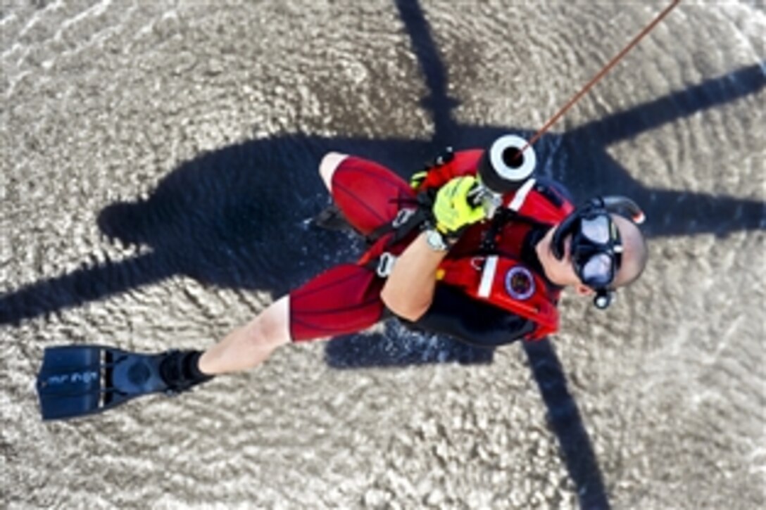 Coast Guard Petty Officer 1st Class Bret Fogle gets hoisted into an MH-60 Jayhawk helicopter near Coast Guard Air Station Elizabeth City, N.C., Aug. 3, 2012. Fogle, a rescue swimmer, is assigned to Coast Guard Air Station Elizabeth City, N.C. The crews conducted hoist training with cadets assigned to the Coast Guard Academy in New London, Conn., as part of their summer visit to the air station.