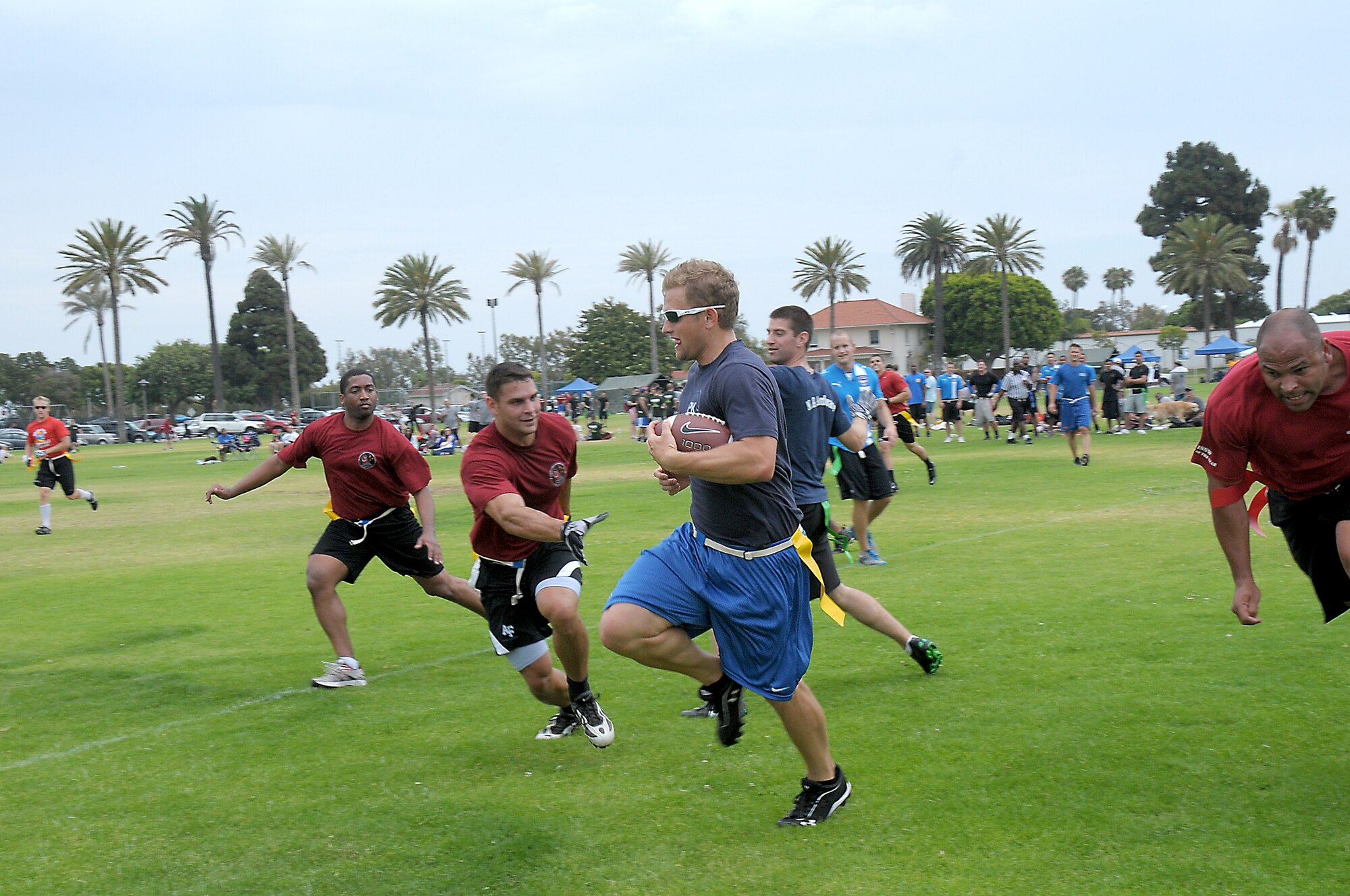 Players from the Infrared Space Systems Directorate are on the defense while players from Contracting run the ball towards the goal during a flag football game. The game was one of many events held during SMC’s annual Sports Day, July 13. The MILSATCOM Team won the football tournament and this year’s overall Sports Day crown.  (Photo by Joe Juarez) 