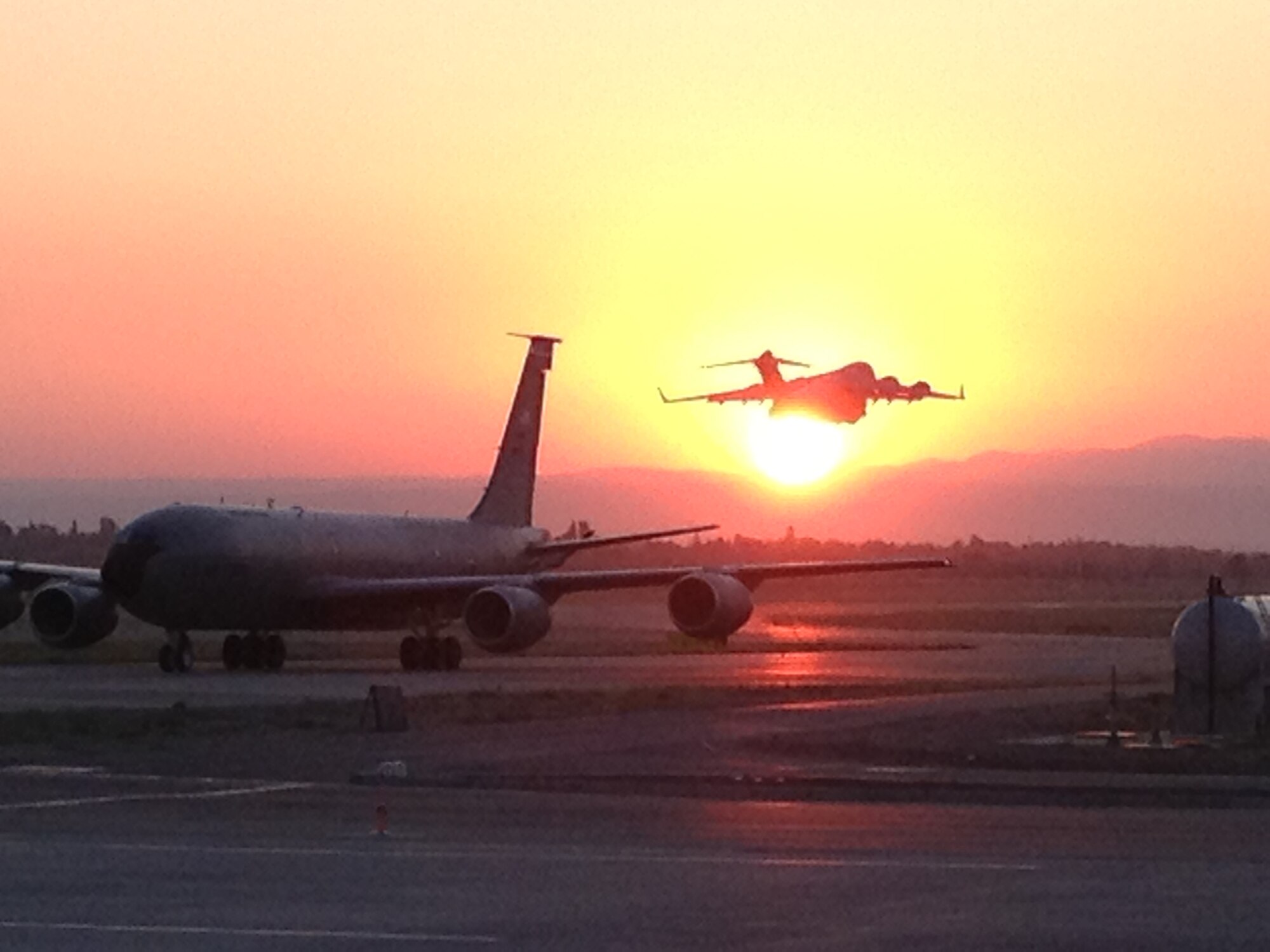 A C-17 Globemaster III, deployed from McChord Field, Wash., takes off into
the sunrise over Manas, Kyrgyzstan, July 15, 2012. The 62nd Airlift Wing, together with its Reserve associate wing, the 446th Airlift Wing, provides a large part of the Air Mobility Command's Global Reach airlift capability. The wing's tasking requirements range from supplying humanitarian airlift relief to victims of disasters, to airdropping troops into the heart of contingency operations in hostile areas. (U.S. Air Force photo/Capt. Joshua Quinn)
