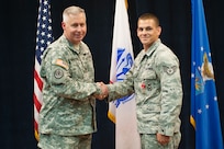 U.S. Army Col. Robert Bridgford, 502nd Air Base Wing vice commander, congratulates Staff Sgt. Christopher Keilman, 902nd Security Forces Squadron military working dog handler, after presenting him with the Bronze Star Medal July 31 at the Joint Base San Antonio-Randolph Kendrick Club. (U.S. Air Force photo by Benjamin Faske)
