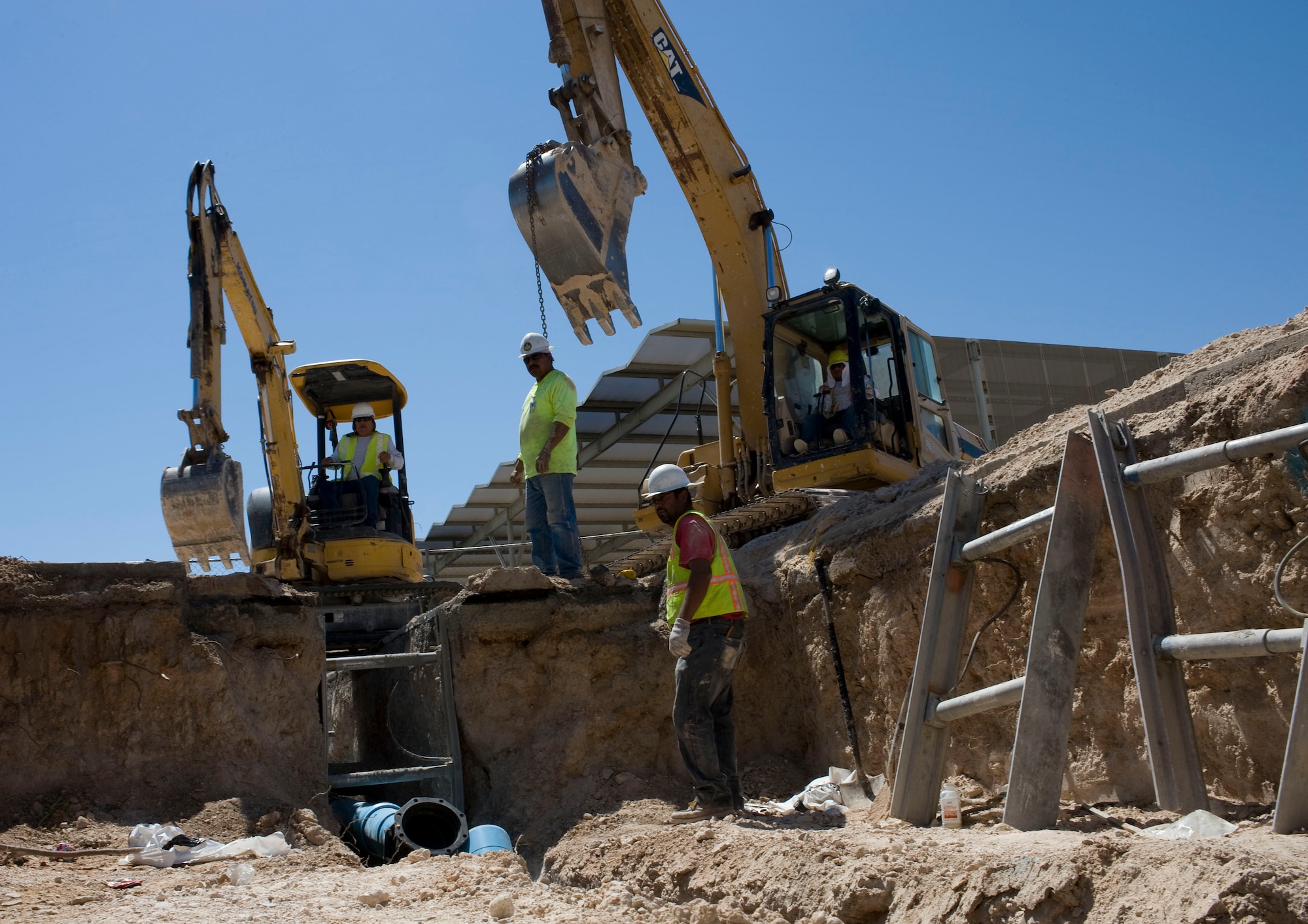 Transwest construction personnel install a pipeline for a water pipe construction project Aug. 8, 2012, at Nellis Air Force Base, Nev. The project will improve potable water quality for the many users served by the existing 60-year-old Tyndall Ave. water main and will increase the water quantity available to the base fire department for airfield and base fire-fighting requirements. (U.S. Air Force photo by Airman 1st Class Christopher Tam)