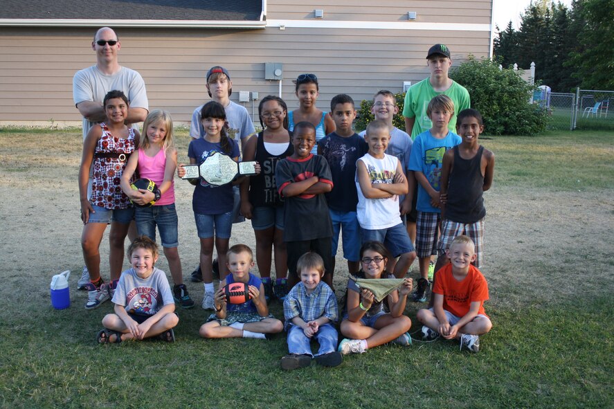 MINOT AIR FORCE BASE, N.D. -- Tech. Sgt. Jeremy Greene, 5th Aircraft Maintenance Squadron, and his "boot camp" kids pose for a group photo during an afternoon of fun and exercise here recently. Sergeant Greene created the exercise group as a way to help the local neighborhood children stay fit and have fun. (U.S. Air Force photo/Kiley Swopes)