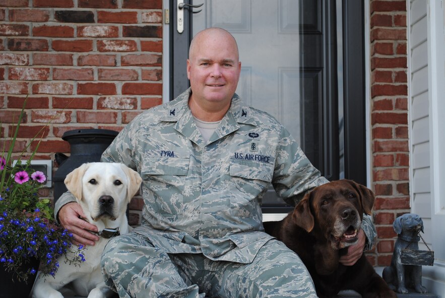 MINOT AIR FORCE BASE, N.D. -- Col. Bill R. Tyra, the new 5th Medical Group commander for Minot Air Force Base, poses for a picture with his two Labrador retrievers, Ginger and Bailey. (Courtesy photo)