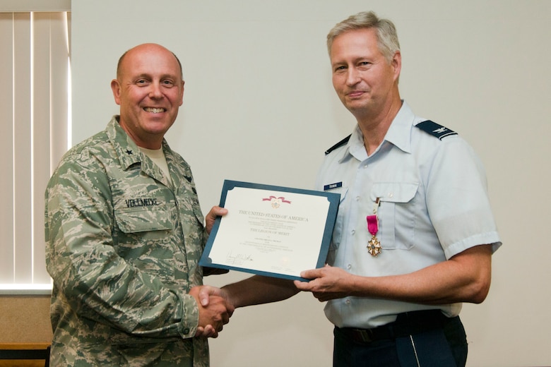 Brig. Gen. Eric Vollmecke presents Colonel Brian Truman with the Legion of Merit during Truman’s retirement ceremony at the 167th Airlift Wing on August 5, 2012. Truman served the unit in several capacities including Wing vice commander before retiring after 33 years of service. (Air National Guard photo by Master Sgt. Emily Beightol-Deyerle)