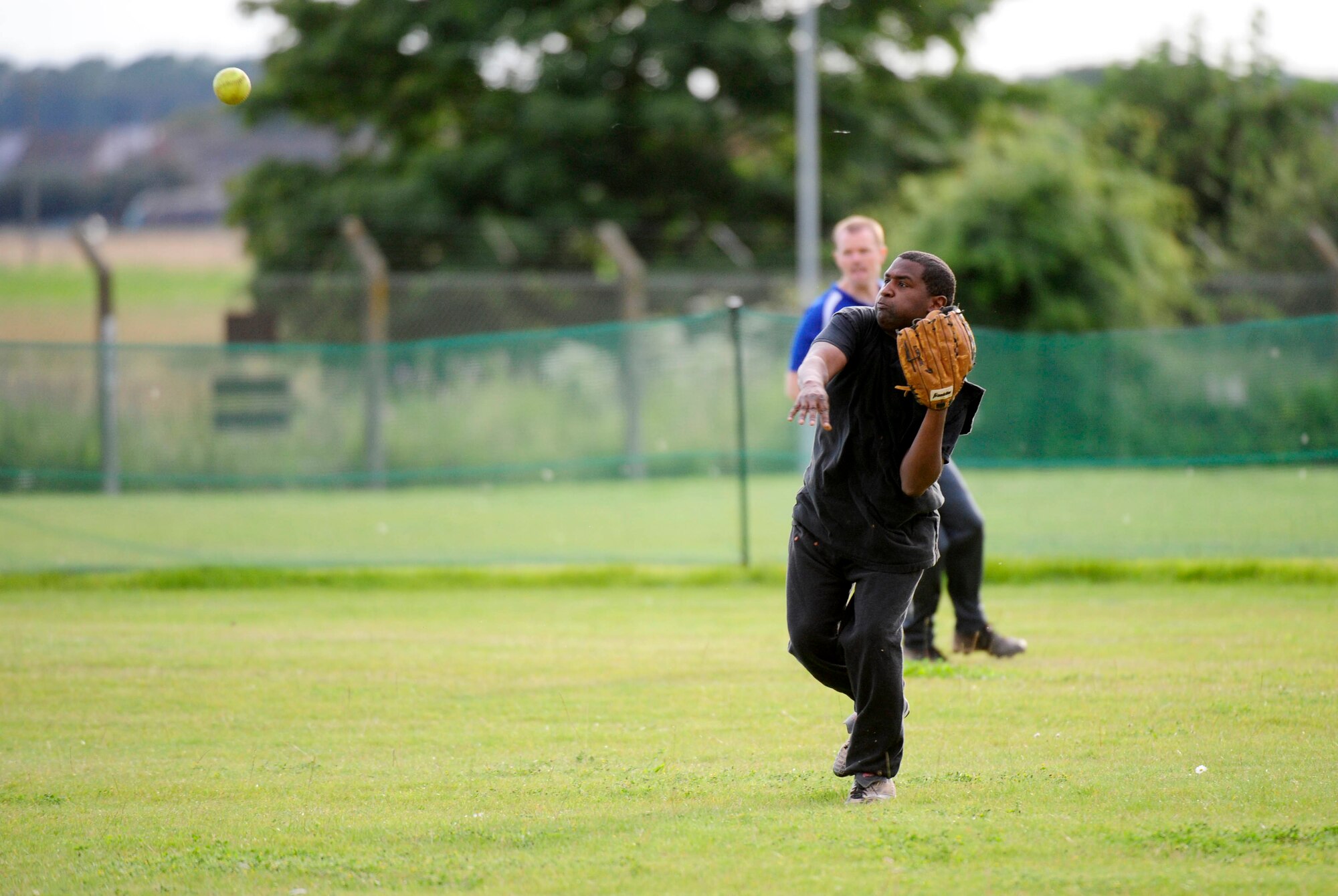 RAF MILDENHALL, England –Michael Davis, 100th Mission Support Group, throws a ball from right field during an intramural softball game against the 100th Aircraft Maintenance Squadron at RAF Mildenhall Aug. 7, 2012. The 100th MXG won the game with a final score of 12 to 10. (U.S. Air Force photo/Senior Airman Ethan Morgan)