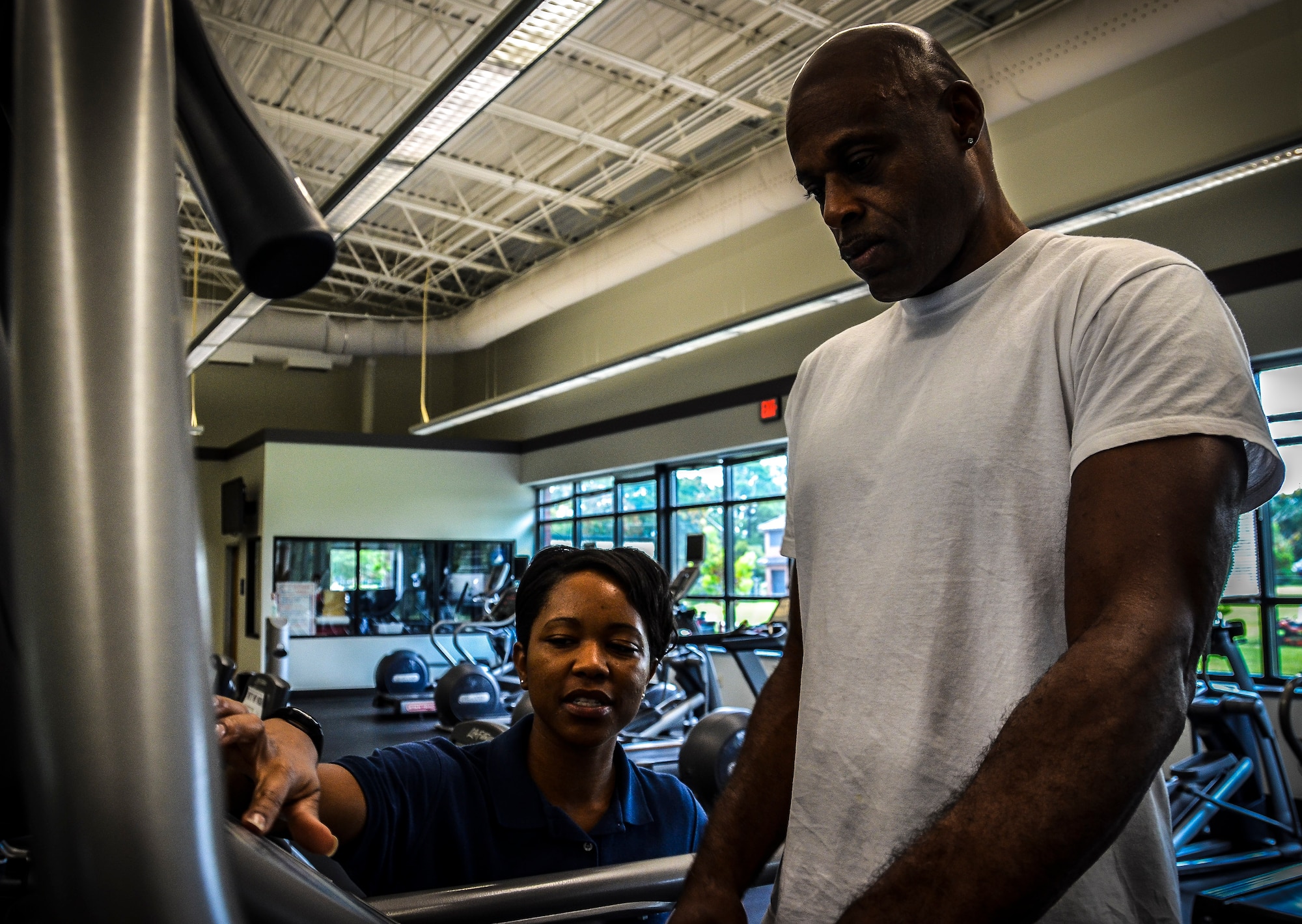 Staff Sgt. Kandra Truesdale, 628th Force Support Squadron Fitness Assessment Cell program manager, assists a customer on a treadmill Aug. 6, 2012, at Joint Base Charleston – Air Base Fitness and Sports Center, S.C. All Fitness and Sports Center staff members are experienced and trained on the equipment used at the facility.  (U.S. Air Force photo by Senior Airman Anthony Hyatt)