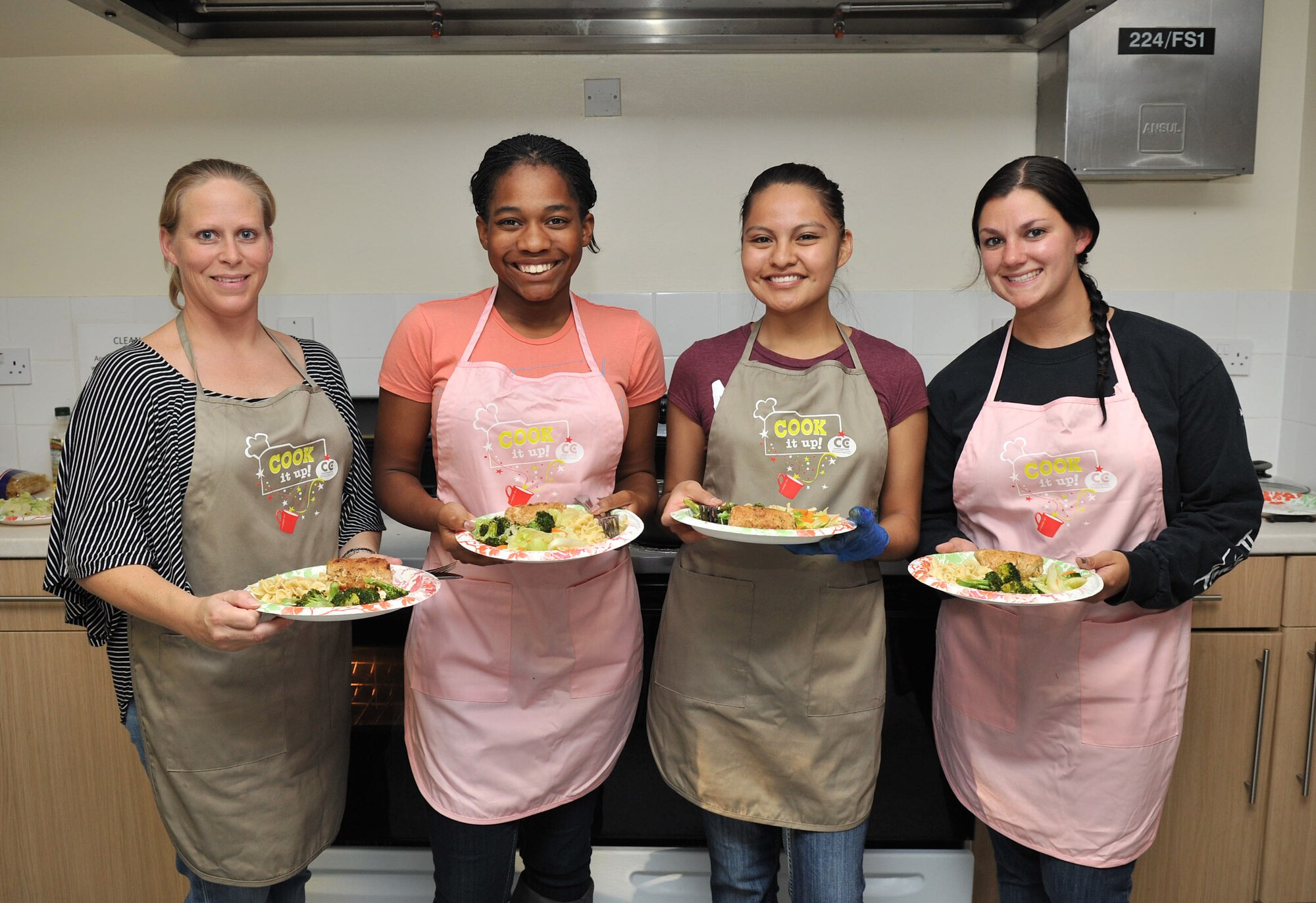RAF MILDENHALL, England - (From Left)  Jennifer Matney, 100th Force Support Squadron, Airman 1st Class Kelsey Waters, 100th Air Refueling Wing Public Affairs, Airman 1st Class Candyce Eaton, 100th Force Support Squadron, Senior Airmen Barbara Thomas, 100th Logistics Readiness Squadron, show off the finished meals during the Cook It Up demonstration in the dormitories here August 7, 2012. The meal consisted of baked broccoli, salad, egg noodles and turkey, ham and cheese rolls which were made as part of one of the Bob Hope Community Center’s morale and wellness programs. (U.S. Air Force photo/Senior Airman Jerilyn Quintanilla)