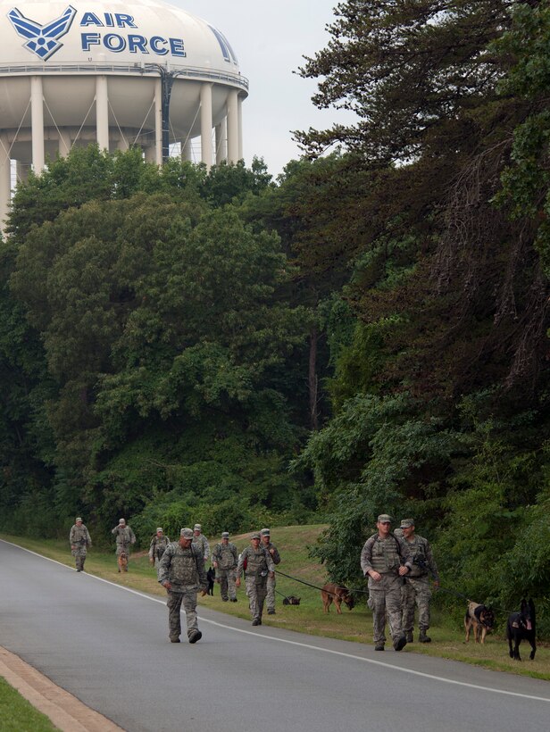 Airman and their military working dogs from the 11th Security Forces Group ruck march around Joint Base Andrews, Md., on Aug. 8, 2012.   MWD Handlers train their dogs for maximum performance of their duties here at Andrews as well as when they deploy. (U.S. Air Force photo/Senior Airman Perry Aston)