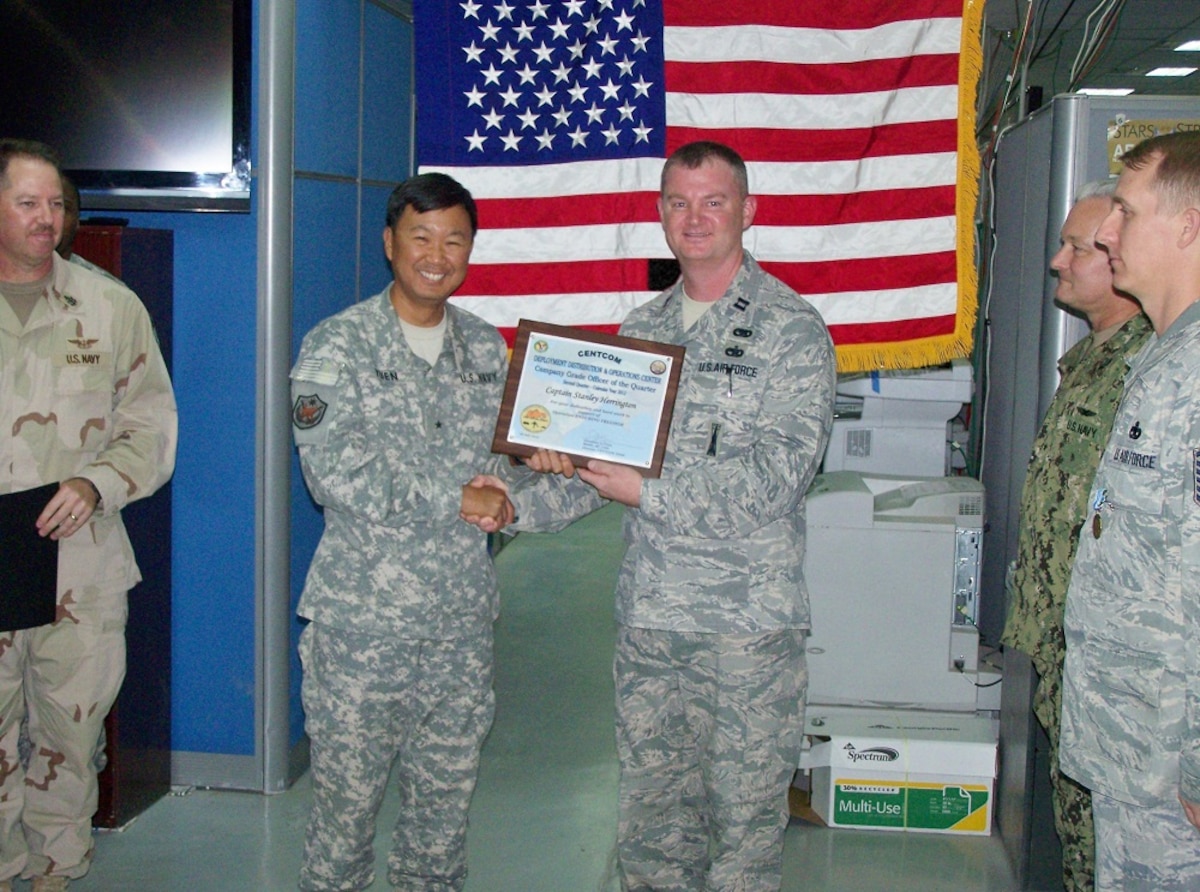 172d AW Capt. Keith Herrington (right) is shown receiving the Company Grade Officer of the Quarter Award while serving in support of Operation Enduring Freedom in Arifjan, Kuwait.  Whle deployed, Herrington has been serving in the CENTCOM DDOC (Deployment Distribution and Operations Center).