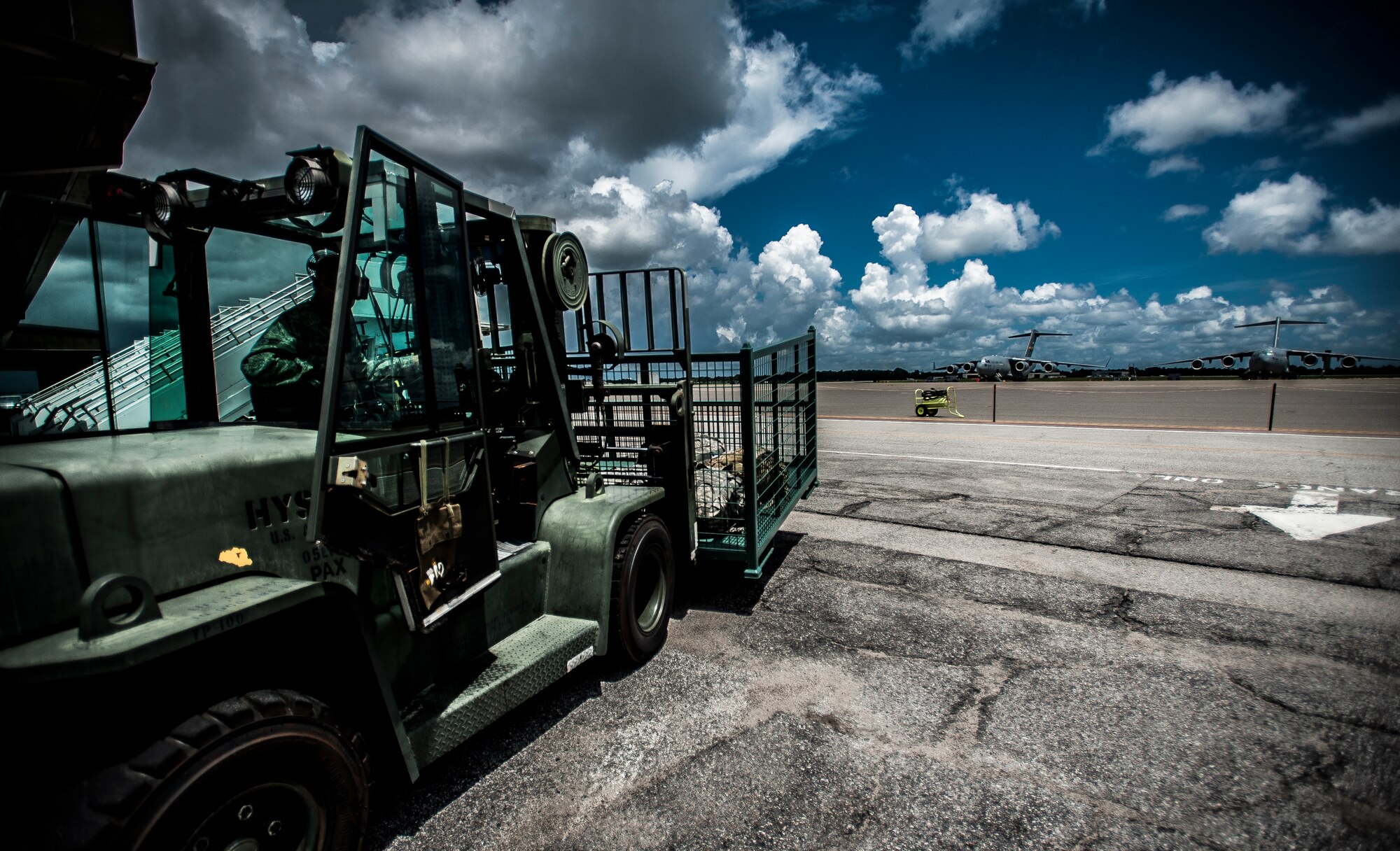 Airman 1st Class Trevor Vascellaro, 437th Aerial Port Squadron passenger service agent, moves a steel baggage bin to the flightline to load bags onto an aircraft Aug. 6, 2012, at Joint Base Charleston – Air Base, S.C. The 437th APS baggage claim service team recently upgraded their baggage bins from weathered wooden bins to steel bins for transporting military member’s baggage to and from aircraft. (U.S. Air Force photo by Senior Airman Dennis Sloan)