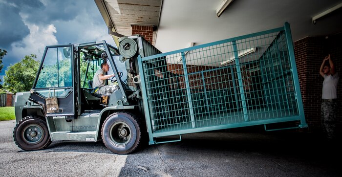 Airman 1st Class Trevor Vascellaro, 437th Aerial Port Squadron passenger service agent, moves a steel baggage bin to the flightline for loading bags onto an aircraft Aug. 6, 2012 at Joint Base Charleston – Air Base, S.C. The 437th APS baggage claim service team recently upgraded their baggage bins from weathered wooden bins to steel bins for transporting military member’s baggage from and to aircraft. (U.S. Air Force photo by Senior Airman Dennis Sloan)