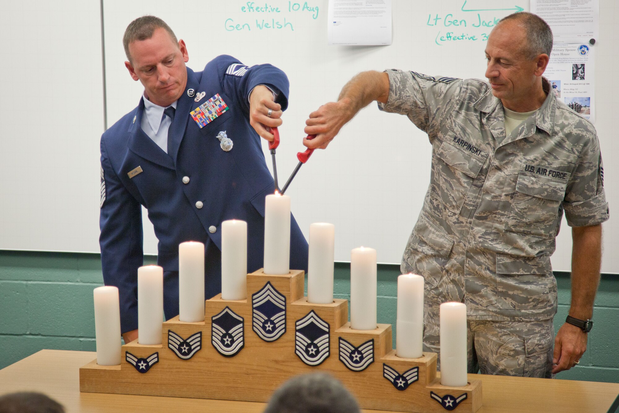 Chief Master Sergeants Jeffery Imsdahl and Richard Karpinski light the candle in recognition of their level of rank.  934th Airlift Wing recognizes their newest Non-Commissioned Officers during an induction ceremony Saturday at Minneapolis-St. Paul Air Reserve Station, Minn.  (U.S. Air Force Photo/Shannon McKay)