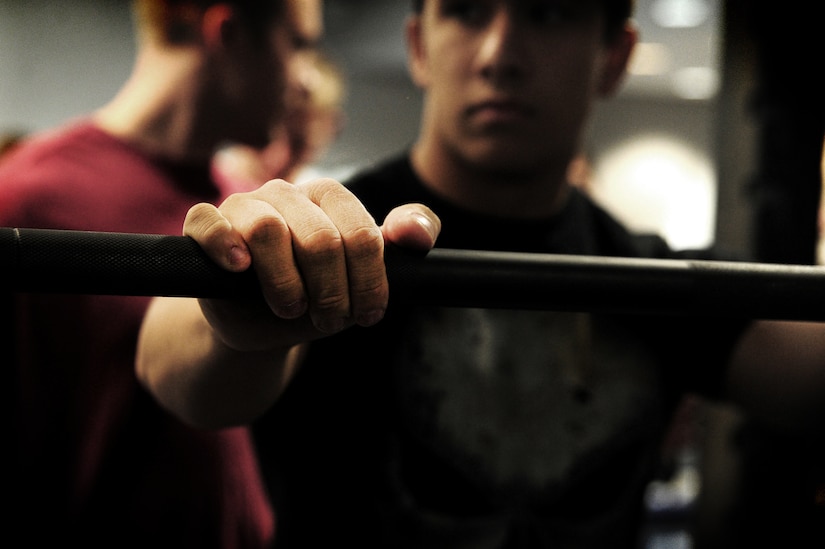 Airman 1st Class Nicholas Byers, 1st Combat Camera Squadron photographer, prepares to perform a during a weightlifting test Aug. 3, 2012, at the fitness center at Joint Base Charleston - Air Base, S.C.  The weightlifting test included bench press, squats, dead lifts and pull-ups. The total amount each Airman lifted was divided by their body weight to give a pound-for-pound strength score in both the male and female categories.  The voluntary program was the first weight lifting test held by the 1st CTCS.  It was started by the unit’s fitness monitors to motivate Airmen to diversify their workouts and show them the importance of incorporating strength training.  (U.S. Air Force photo/ Staff Sgt. Nicole Mickle)