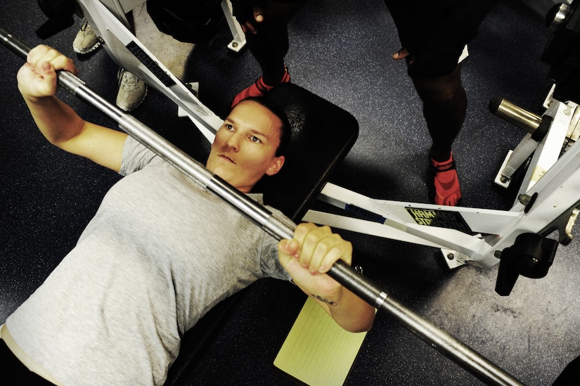 Tech. Sgt. Amanda Helton, 1st Combat Camera Squadron broadcaster, bench presses during a weightlifting test Aug. 3, 2012, at the fitness center at Joint Base Charleston - Air Base, S.C. The weightlifting test included bench press, squats, dead lifts and pull-ups. The total amount each Airman lifted was divided by their body weight to give a pound-for-pound strength score in both the male and female categories.  The voluntary program was the first weight lifting test held by the 1st CTCS. It was started by the unit’s fitness monitors to motivate Airmen to diversify their workouts and show them the importance of incorporating strength training.  (U.S. Air Force photo/ Staff Sgt. Nicole Mickle)