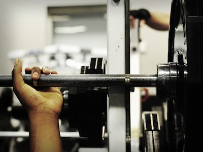 Airman 1st Class Tre Gibbs, 1st Combat Camera Squadron photographer, prepares to bench press during a weightlifting test Aug. 3, 2012, at the fitness center at Joint Base Charleston - Air Base, S.C.  The weightlifting test included bench press, squats, dead lifts and pull-ups. The total amount each Airman lifted was divided by their body weight to give a pound-for-pound strength score in both the male and female categories.  The voluntary program was the first weight lifting test held by the 1st CTCS.  It was started by the unit’s fitness monitors to motivate Airmen to diversify their workouts and show them the importance of incorporating strength training.  (U.S. Air Force photo/ Staff Sgt. Nicole Mickle)