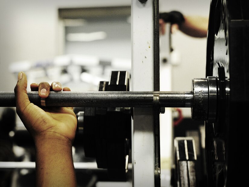 Airman 1st Class Tre Gibbs, 1st Combat Camera Squadron photographer, prepares to bench press during a weightlifting test Aug. 3, 2012, at the fitness center at Joint Base Charleston - Air Base, S.C.  The weightlifting test included bench press, squats, dead lifts and pull-ups. The total amount each Airman lifted was divided by their body weight to give a pound-for-pound strength score in both the male and female categories.  The voluntary program was the first weight lifting test held by the 1st CTCS.  It was started by the unit’s fitness monitors to motivate Airmen to diversify their workouts and show them the importance of incorporating strength training.  (U.S. Air Force photo/ Staff Sgt. Nicole Mickle)