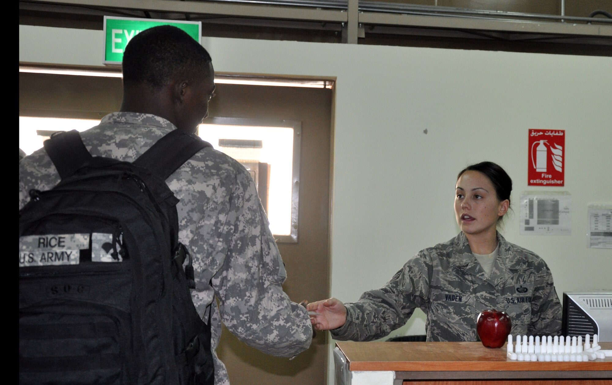 SOUTHWEST ASIA - Staff Sgt. Melynda Vaden, Theater Gateway team member, processes a Soldier for a flight as he heads out for rest and recouperation leave. The gateway team consists of five Airmen who process all branches of service transiting through the Central Command area of responsibility as they return to the states on leave, R&R or redeployment. (U.S. Air Force photo/Master Sgt. Kristina Barrett)