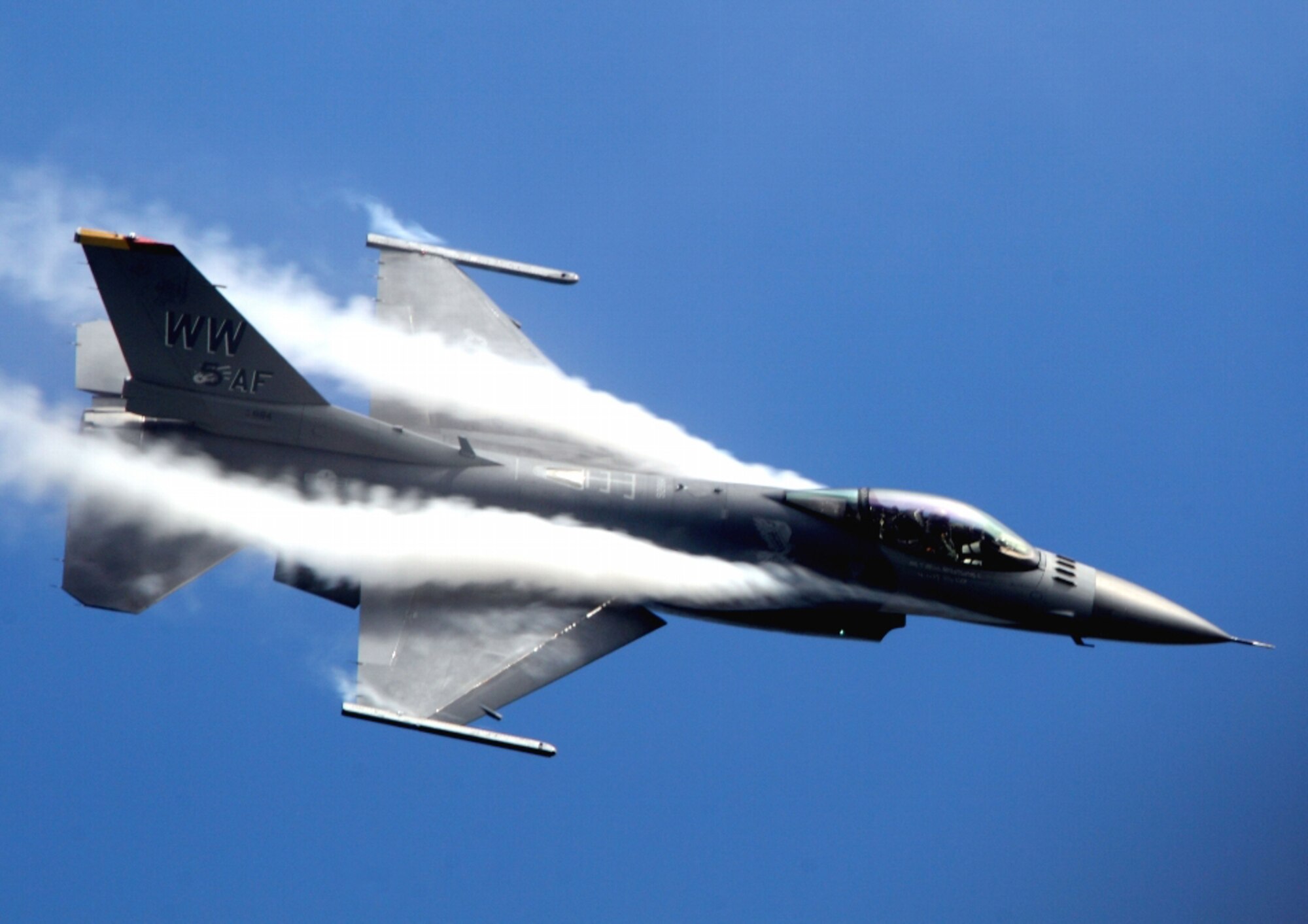 Water condensation forms on the wings of an F-16 Fighting Falcon as Capt. Chris Nations, Pacific Air Forces Demonstration Team and 14th Fighter Squadron pilot from Misawa Air Base, Japan, flies the jet during a practice performance at the  Chitose Air Base Air Show, Japan, Aug. 3, 2012. Approximately 61,000 spectators attended the Air Show this year. (Courtesy photo by Yasuhiko Yusa)