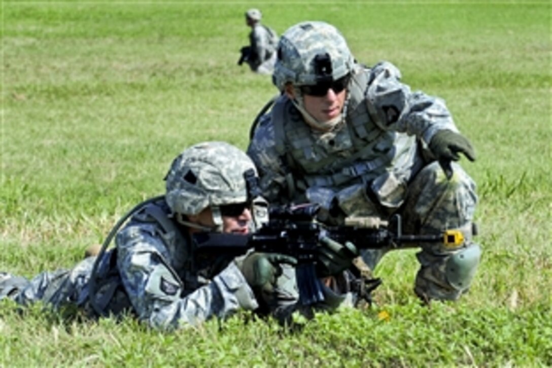 A soldier points to his battle buddy while other soldiers load mock casualties into UH-60A Black Hawk medevac helicopters during a practice on Fort Campbell, Ky., Aug. 7, 2012. The soldiers are assigned to the 4th Brigade Combat Team.