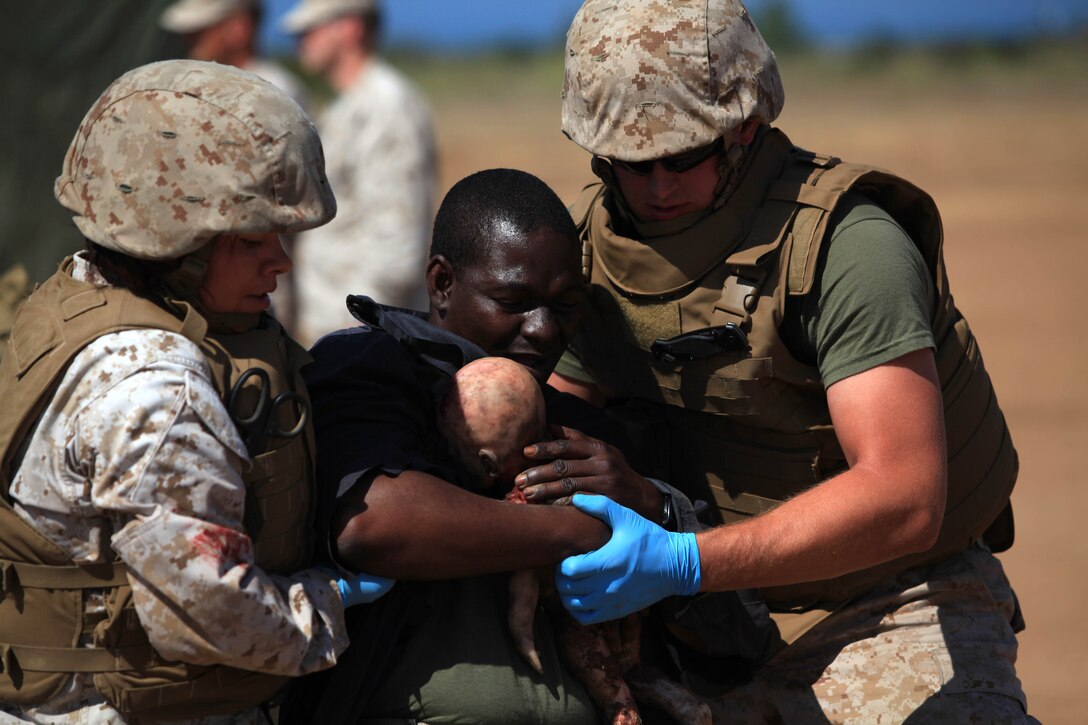 Corpsmen assist an acting casualty and a simulated infant. A Pre-deployment Mass Casualty Care Course was held to ensure medical operational forces maintain clinical sustainment and combat readiness at Camp Pendleton's Tango Training Area, Aug 8.