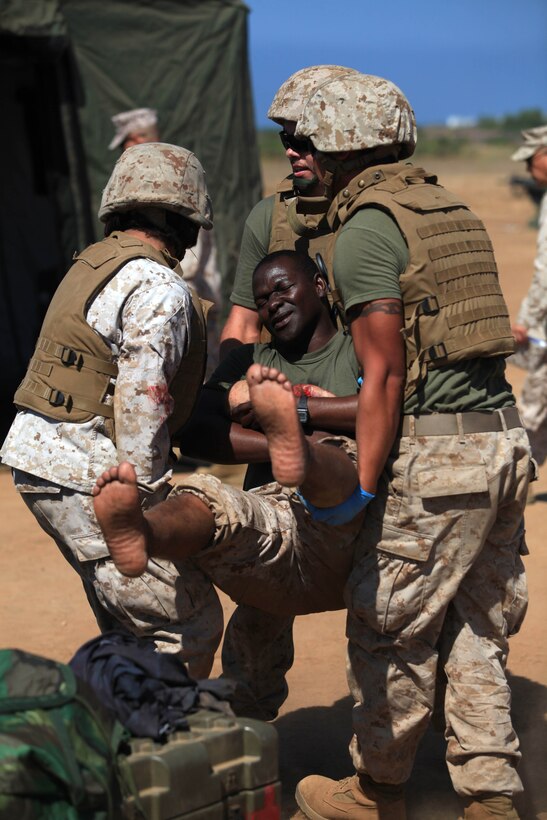 Corpsmen transport an acting casualty and a simulation infant to a secure location for treatment. A Pre-deployment Mass Casualty Care Course was held to ensure medical operational forces maintain clinical sustainment and combat readiness at Camp Pendleton's Tango Training Area, Aug 8.