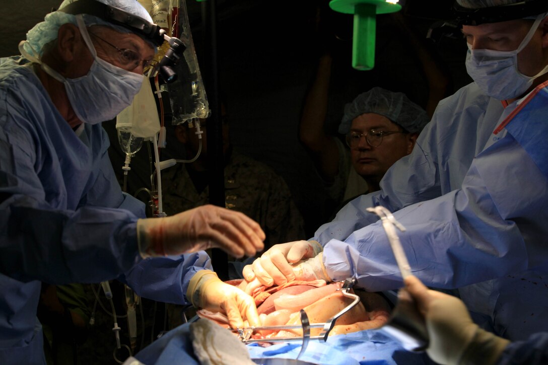 Surgeons perform an exploratory laparotomy on a patient during a training simulation at Camp Pendleton's Tango Training Area, Aug 8. A Pre-deployment Mass Casualty Care Course was held to ensure medical operational forces maintain clinical sustainment and combat readiness.