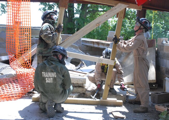 Aligning brace.MUSCATATUCK URBAN TRAINING CENTER, Ind. — Marines from the Marine Chemical, Biological Incident Response Force use wooden brace to help support a steel beam of a collapsing building during a Vibrant Response 13 field training exercise at the Muscatatuck Urban Training Center, Ind., July 29. The rescue technicians were responsible for decontaminating treating and evacuating role-players, acting as “survivors”, during the man-made disaster-training venue. The Marines worked to safely secure the building so they could further search the area for survivors in need of aid.(U.S. Army photo by Sgt. Terence Ewings, Army North PAO)