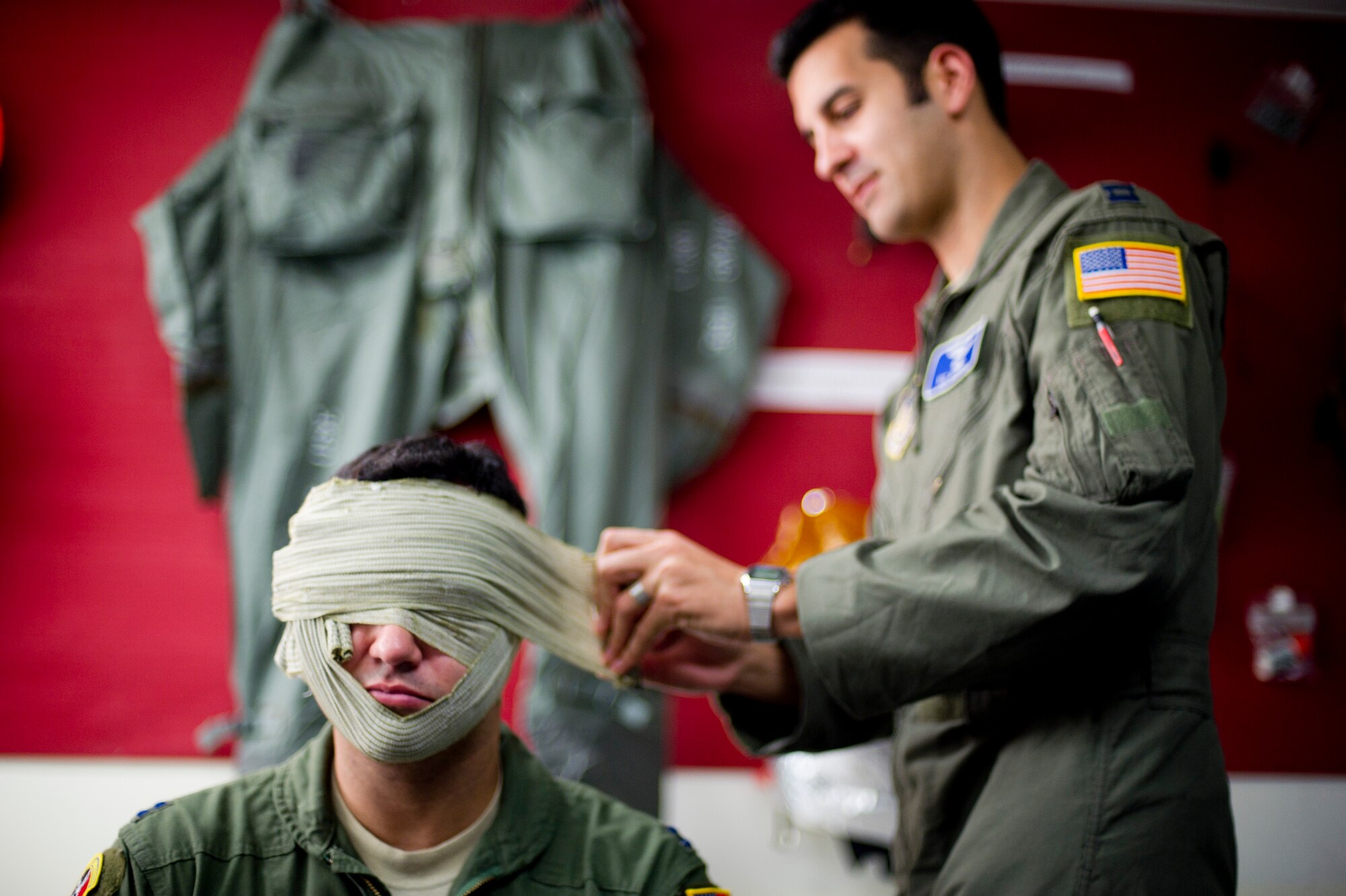 YOKOTA AIR BASE, Japan -- Capt. Nicolas Morris, 5th Air Force, performs a headwrap on Capt. Raul Roldan, 36th Airlift Squadron, during survival, evasion, resistance and escape training Aug 7, 2012, at Yokota Air Base, Japan. This block of the training covered self-aid and buddy care, teaching students how to properly care for wounded service members after an emerency landing. (U.S. Air Force photo by Staff Sgt Stacy Moless)
