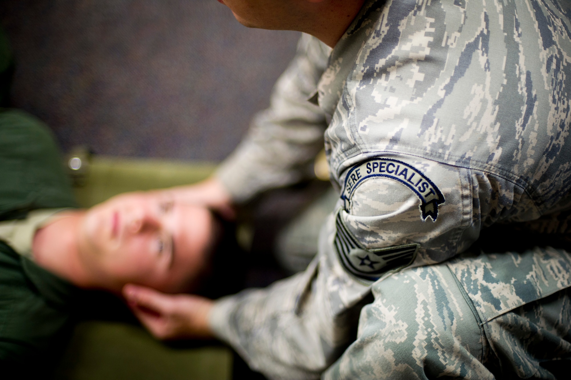 YOKOTA AIR BASE, Japan -- Tech. Sgt. Benjamin Rosciglione, a 374th Operation Support Squadron survival, evasion, resistance and escape instructor, demonstrates positioning someone on a litter Aug 7, 2012 at Yokota Air Base, Japan. Aircew memebers participate in self-aid and buddy care during a block of refresher SERE training. (U.S. Air Force photo by Staff Sgt Stacy Moless)