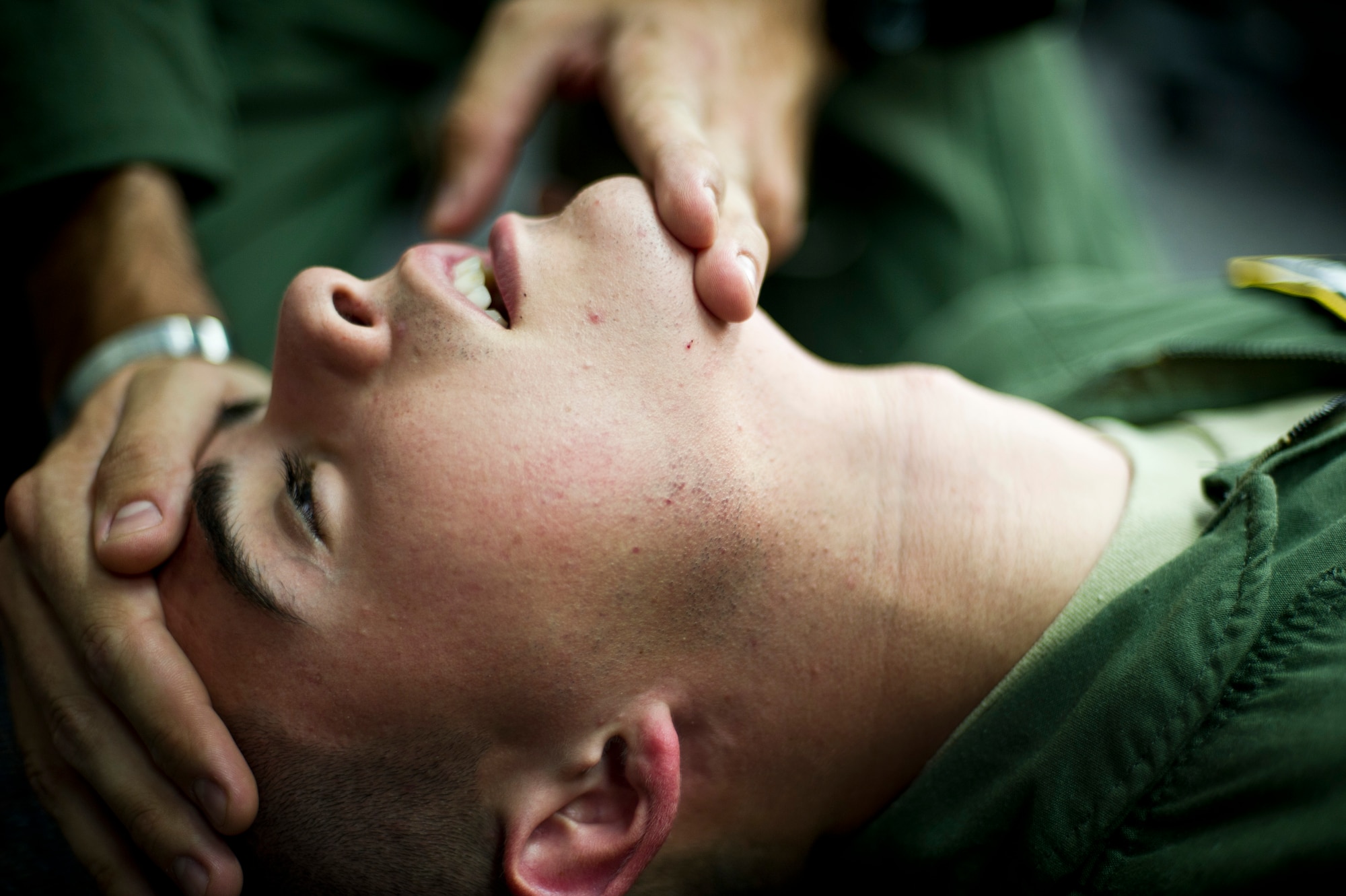 YOKOTA AIR BASE, Japan -- Airman Paul Hensley, 36th Air Lift Squadron, participates in self-aid and buddy care during survival, evasion, resistance and escape training Aug 7, 2012, at Yokota Air Base, Japan. Hensley layed down while his partner demostrated a head tilt, chin lift procedure for opening his airway for unobstructed breathing.(U.S. Air Force photo by Staff Sgt Stacy Moless)
