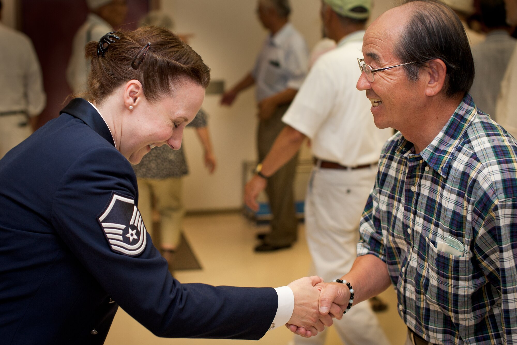 SHIOGAMA CITY, Japan -- Master Sgt. Paula Goetz bows and shakes hands with a Japanese audience member following the a performance at the Yu Hall, Shiogama City, Miyagi Prefecture, Japan on Aug 7, 2012. This was Goetz's last performance as a member of the Band of the Pacific-Asia. (U.S. Air Force photo/Staff Sgt. Josh Voyles)